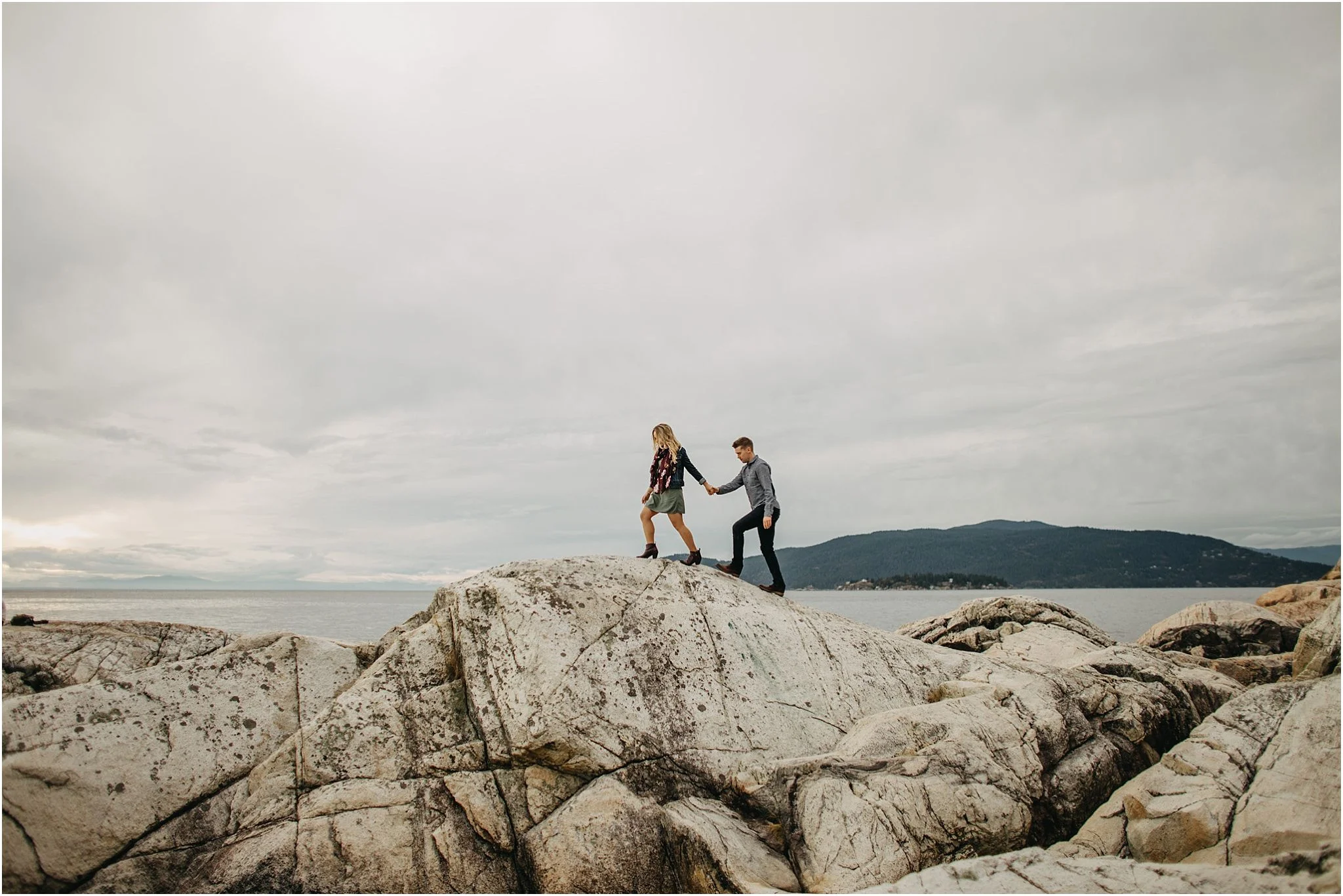 woman leading man walking on rock at lighthouse park