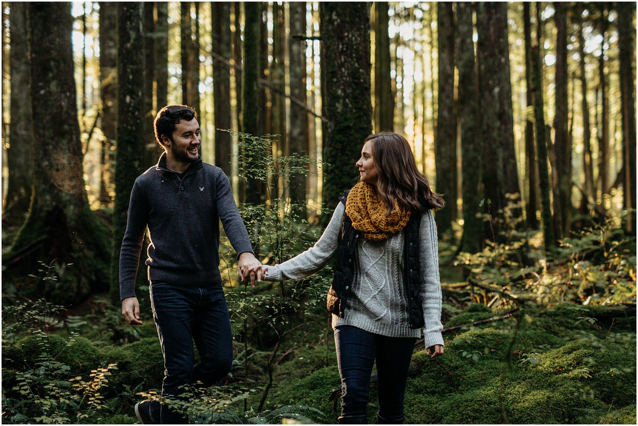 girl leading guy out of forest engagement session