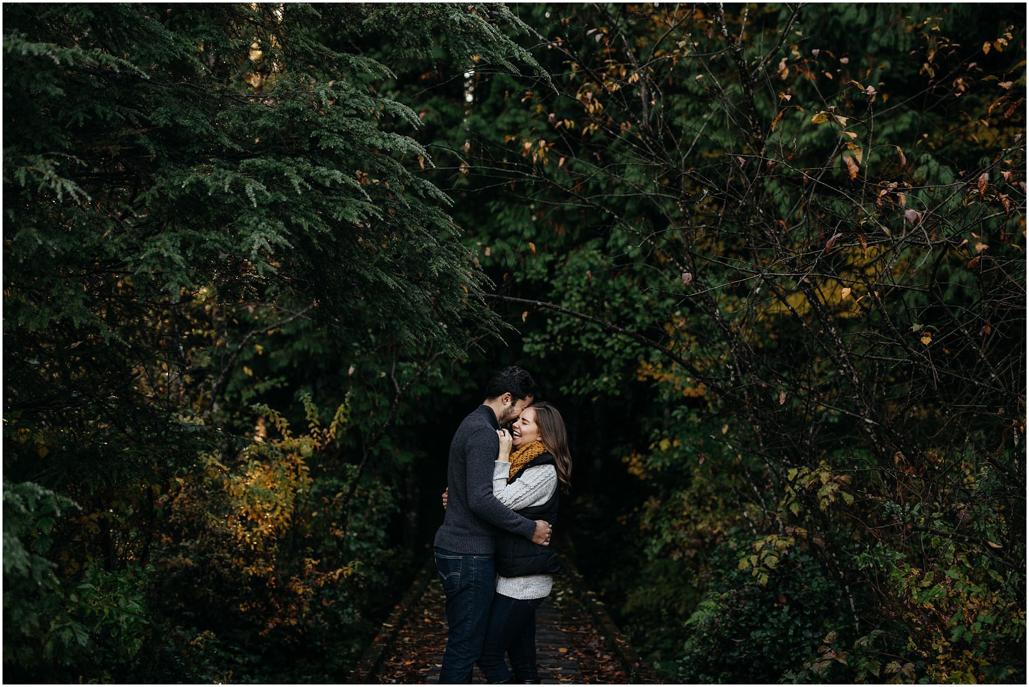 couple in forest hugging engagement photos fall