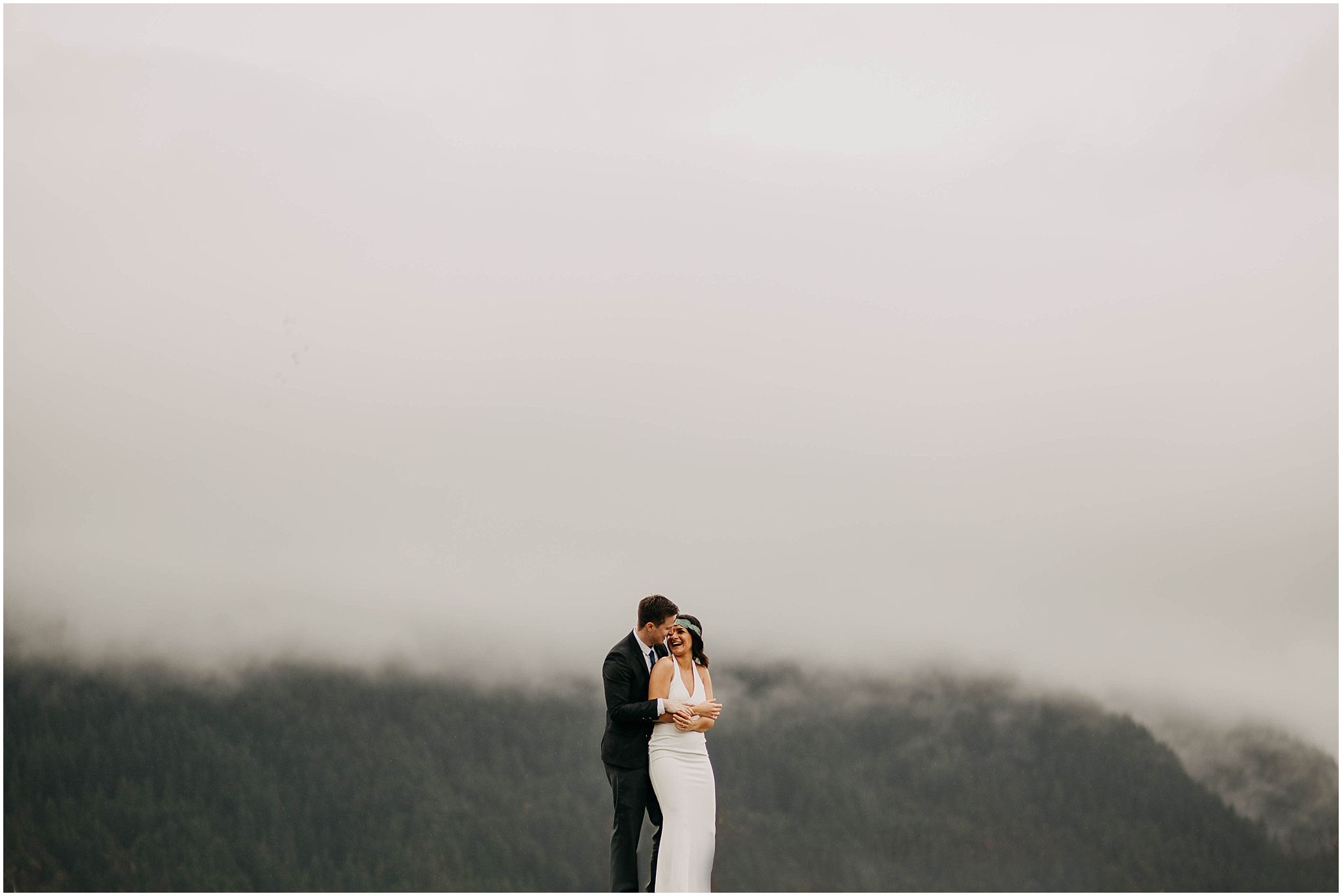 bride and groom in front of foggy mountains pitt lake