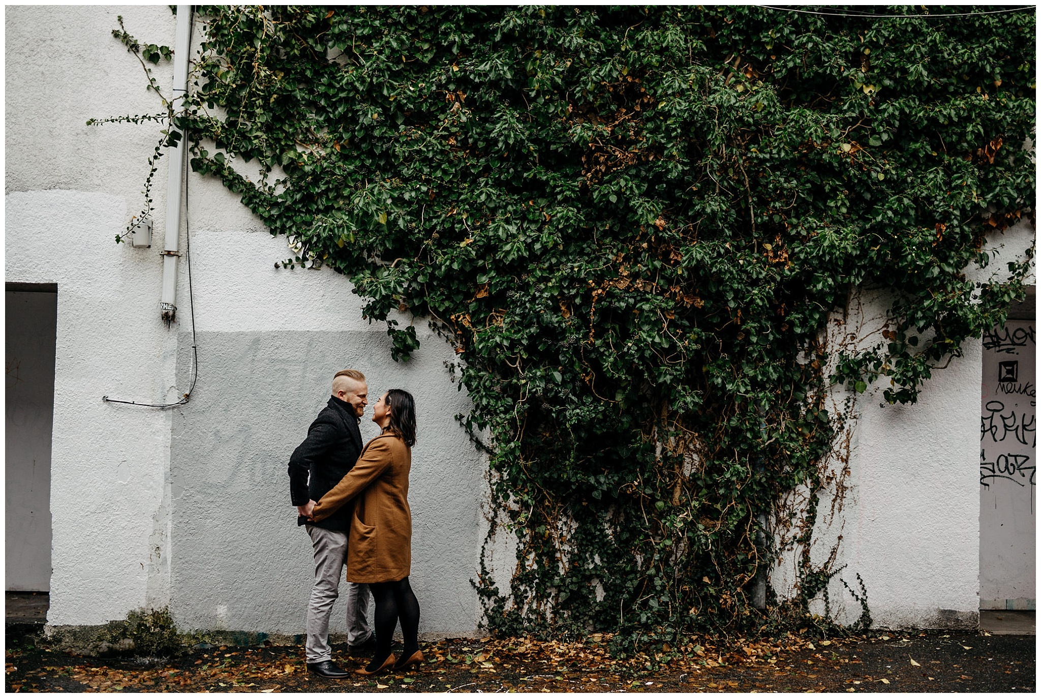 engaged couple holding hands vines on wall vancouver alley engagement