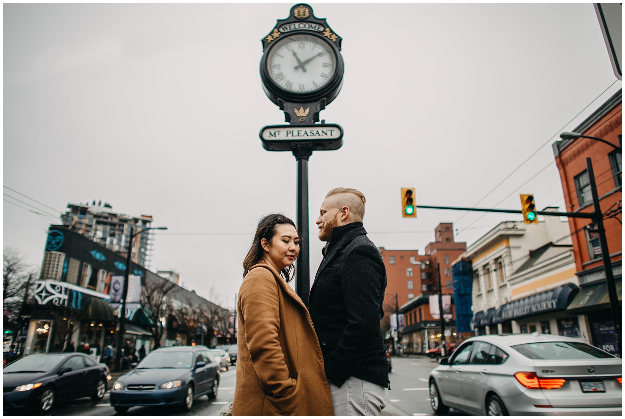 couple standing in front of mount pleasant clock vancouver city engagement