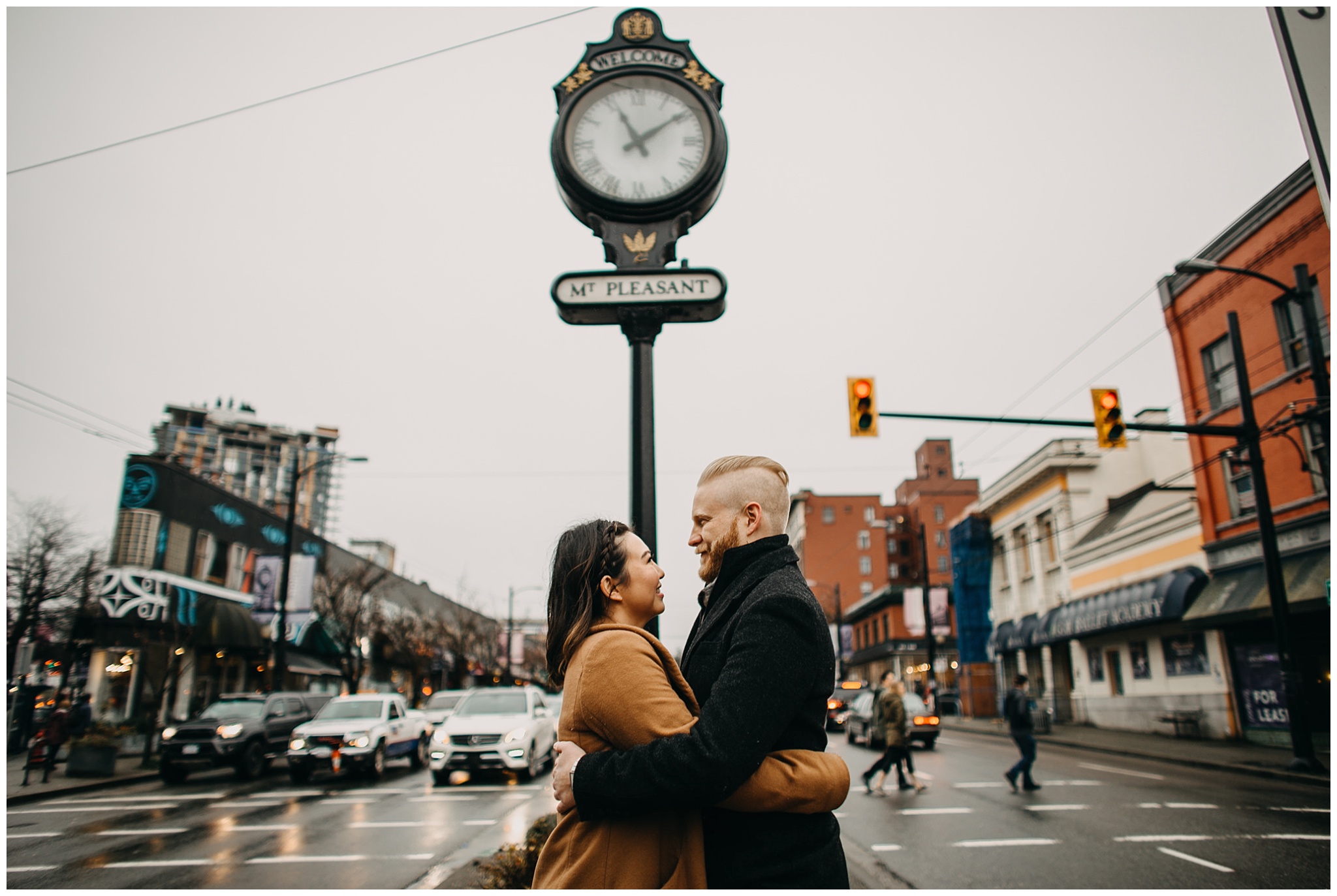 couple hugging in front of mount pleasant clock vancouver city engagement