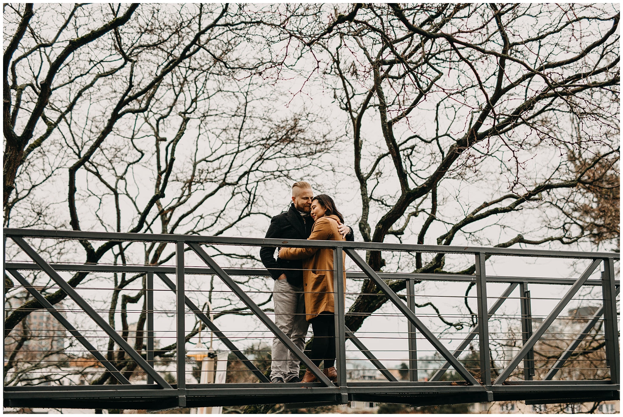 couple hug on bridge on granville island vancouver engagement