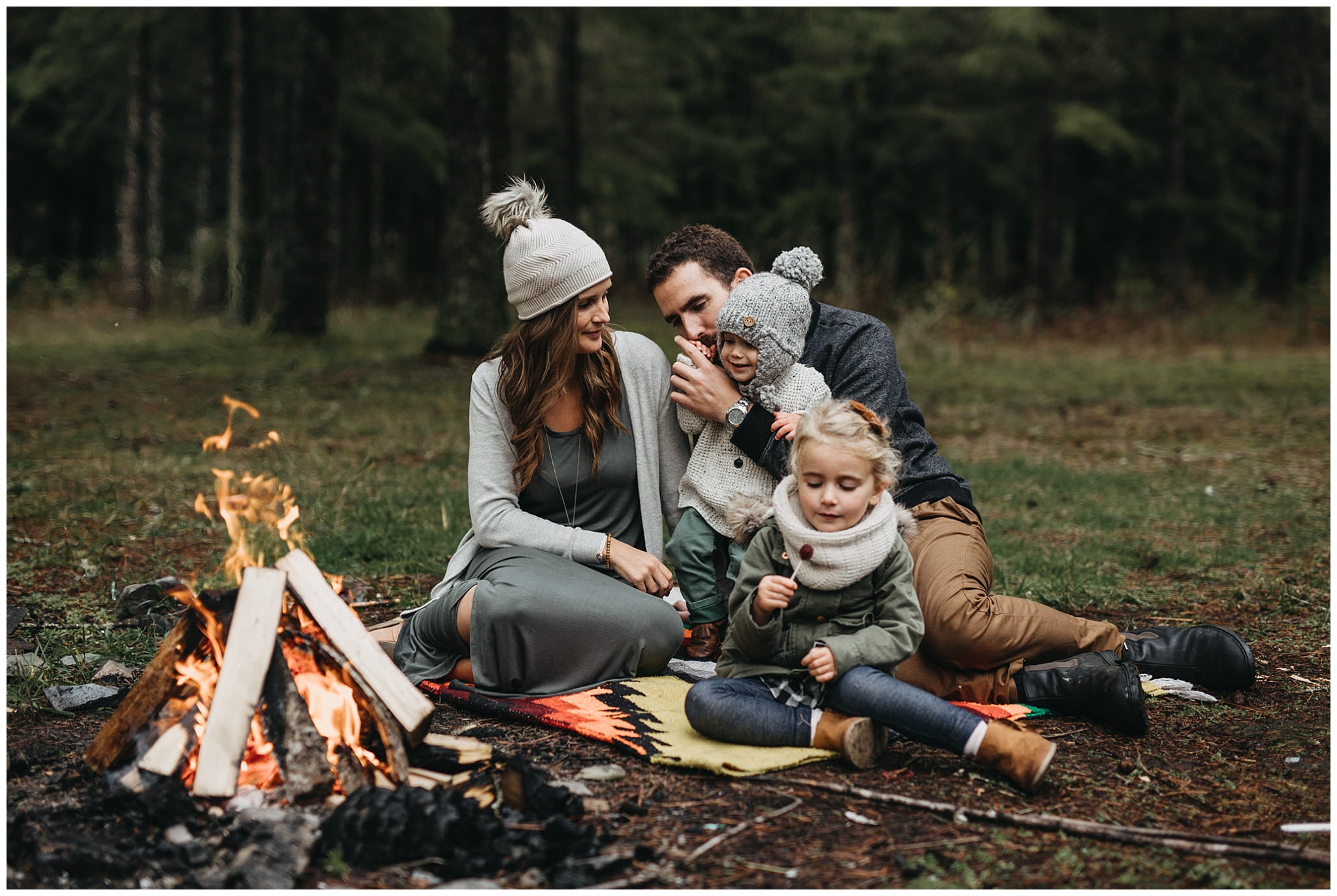 family sitting around campfire on blanket chilliwack forest family photos