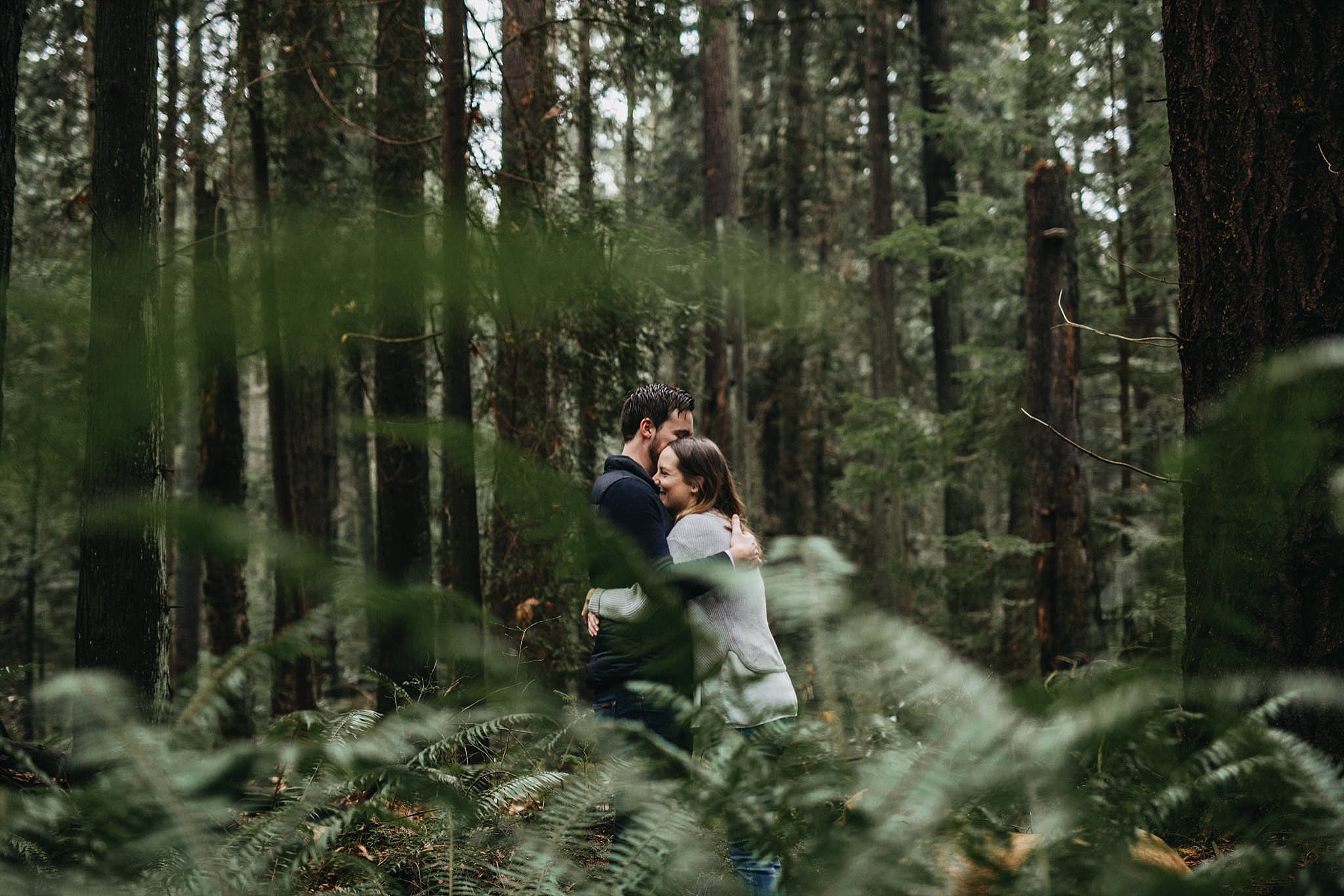 tall trees ferns forest pacific spirit park couples engagement