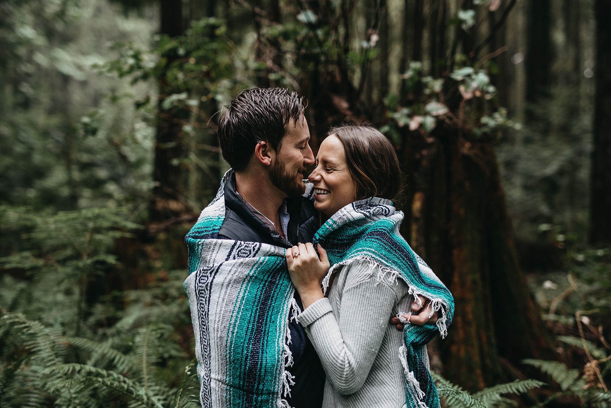 couple candid smile forest pacific spirit park engagement