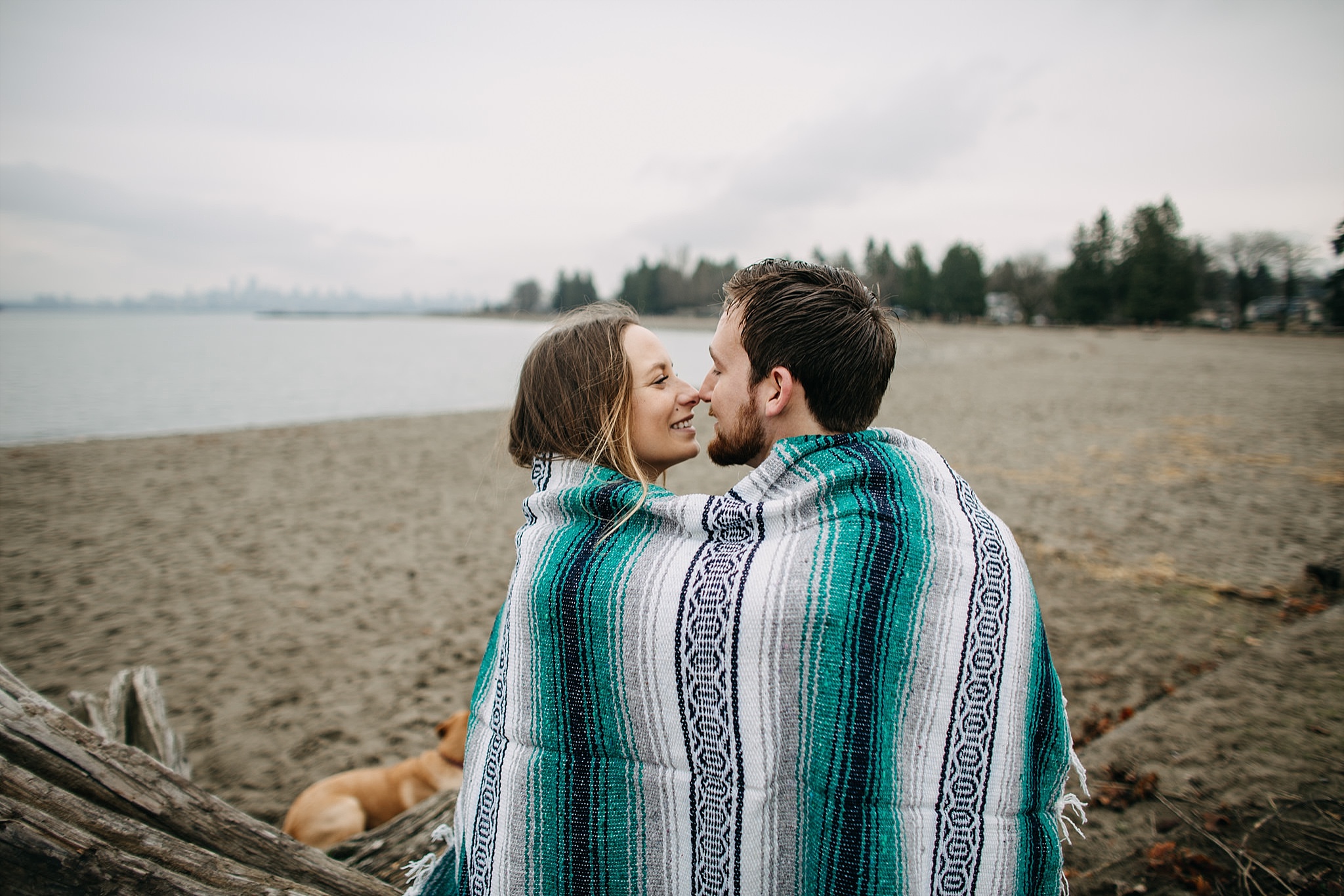 couple and puppy blanket beach spanish banks engagement