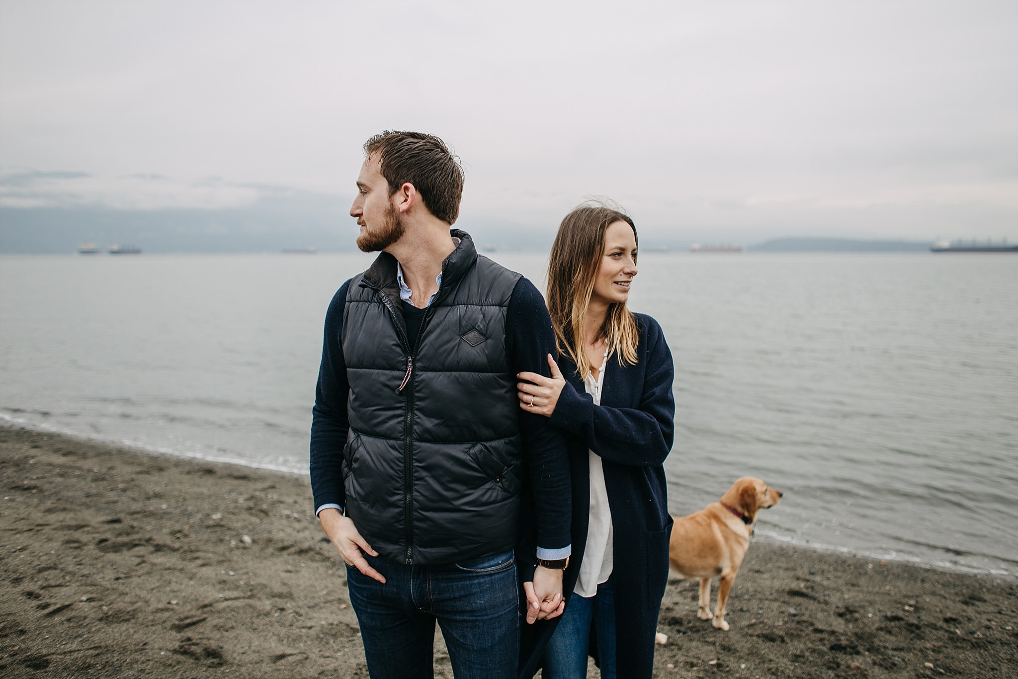 couple with puppy on beach looking away spanish banks engagement