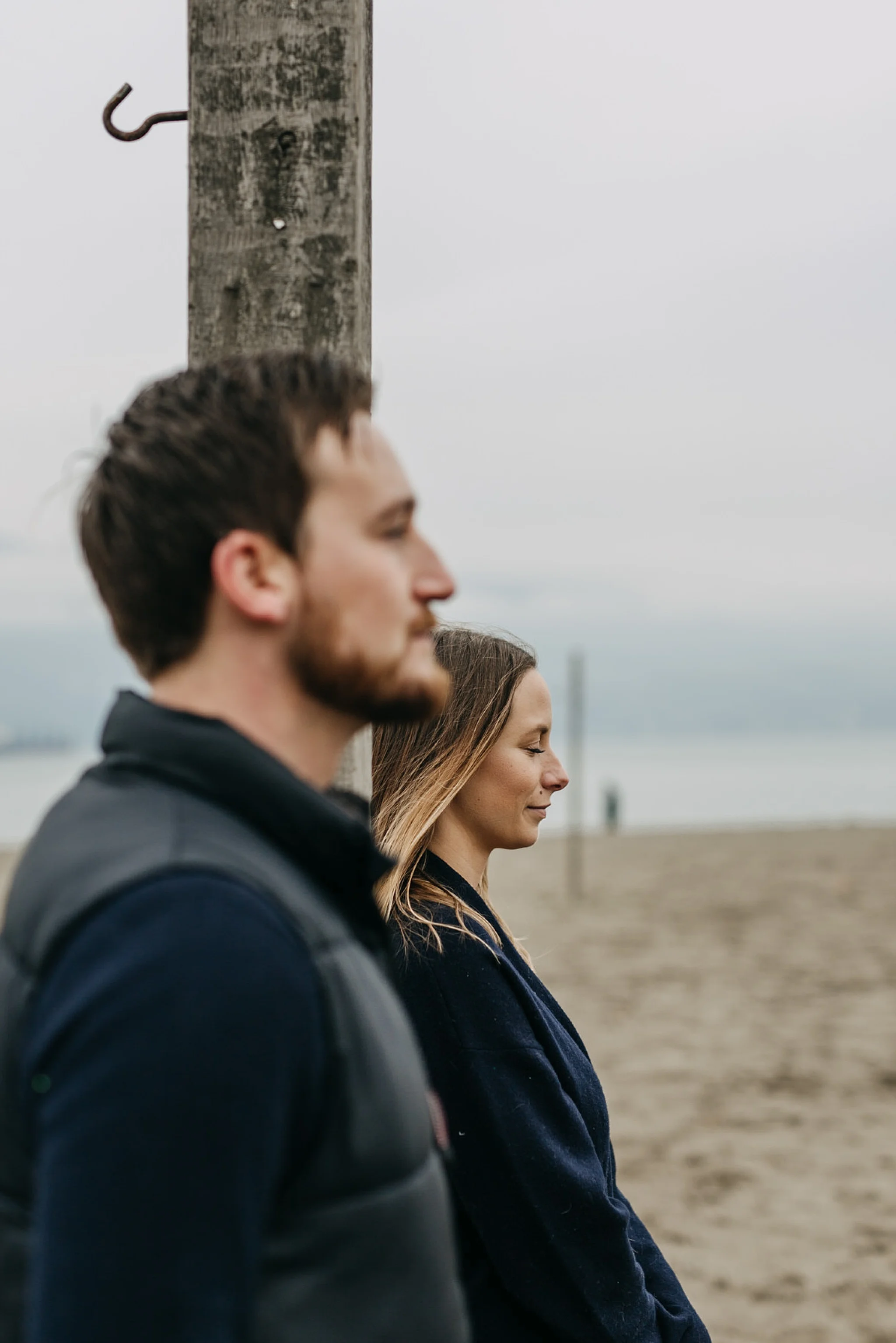 couple next to each other on beach spanish banks