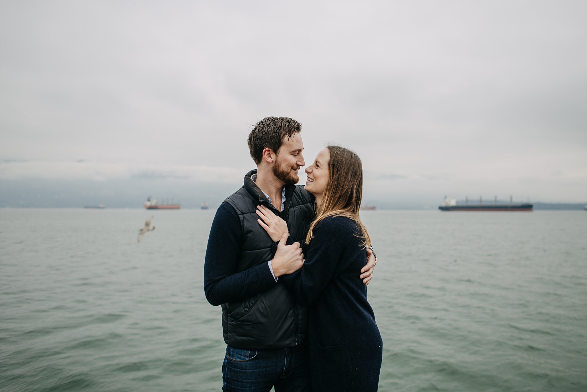 couple on dock by ocean pacific northwest spanish banks engagement
