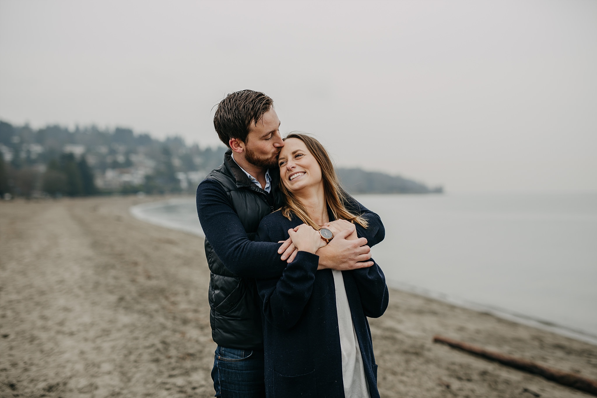 couple arms wrapped around kissing beach spanish banks engagement