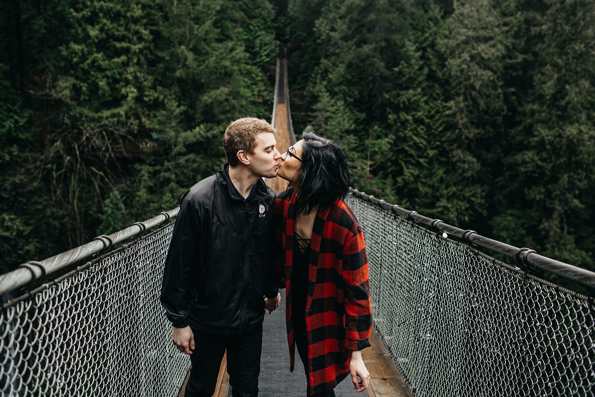 couple kissing on capilano suspension bridge engagement