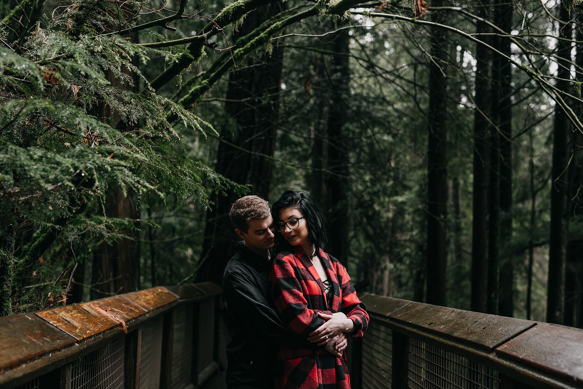 couple hugging on path at capilano suspension bridge for engagement photos