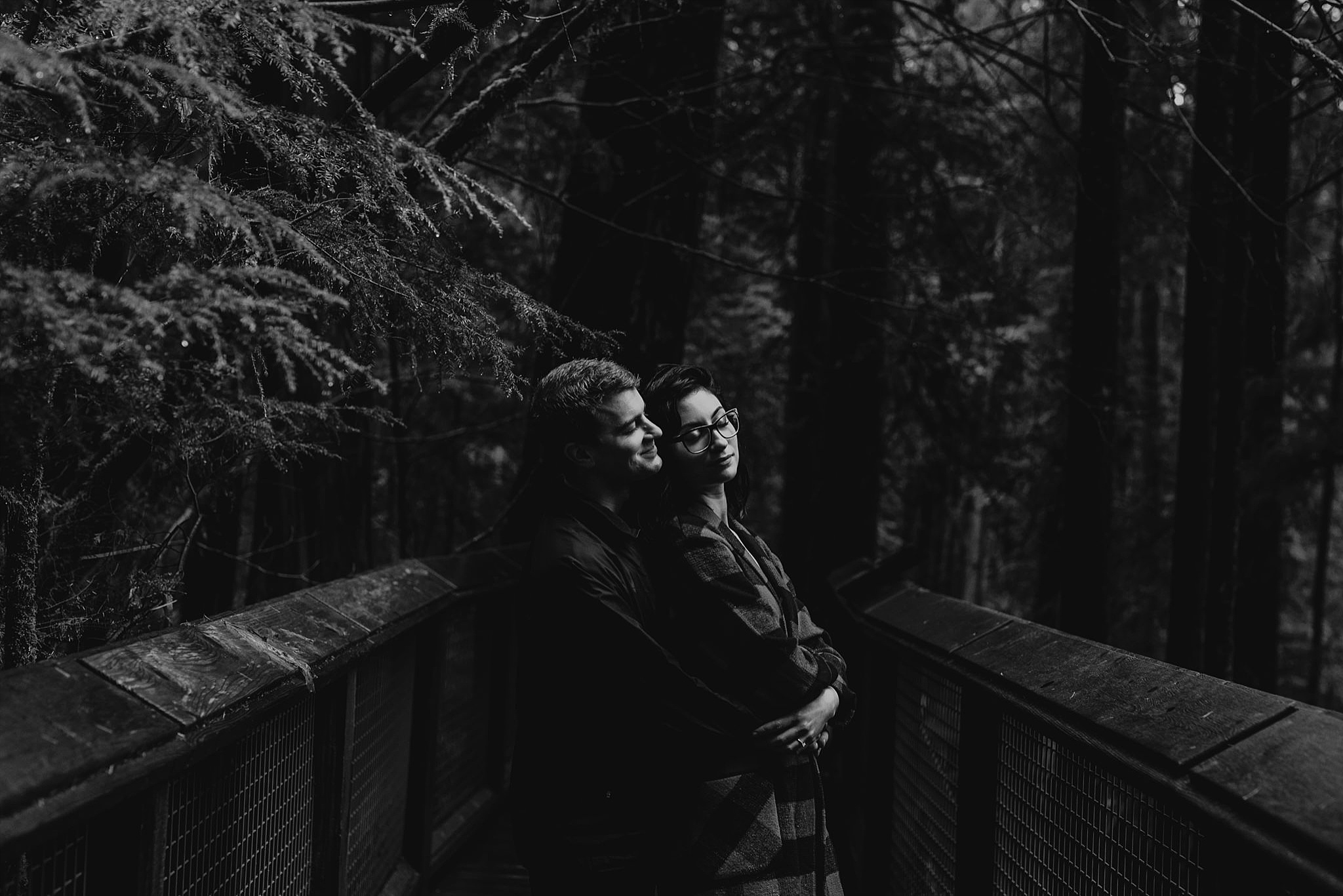 moody black and white couple engagement photos capilano suspension bridge