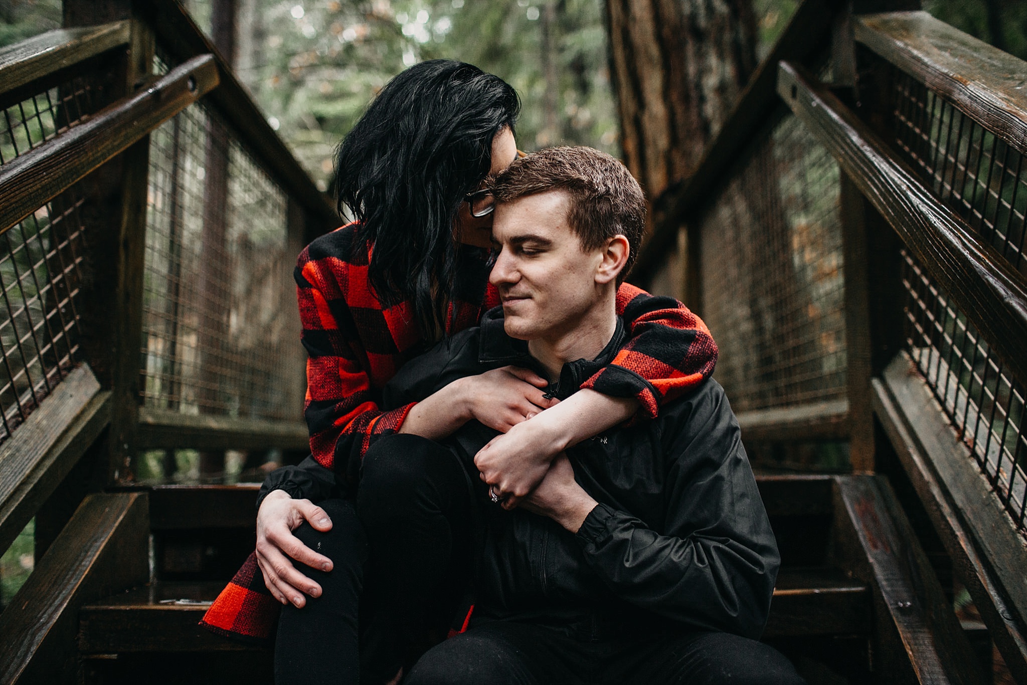 couple snuggle intimate engagement photos capilano suspension bridge