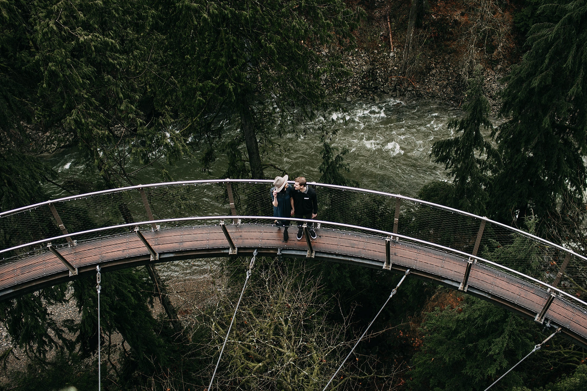 couple walking on cliff walk capilano suspension bridge engagement photos