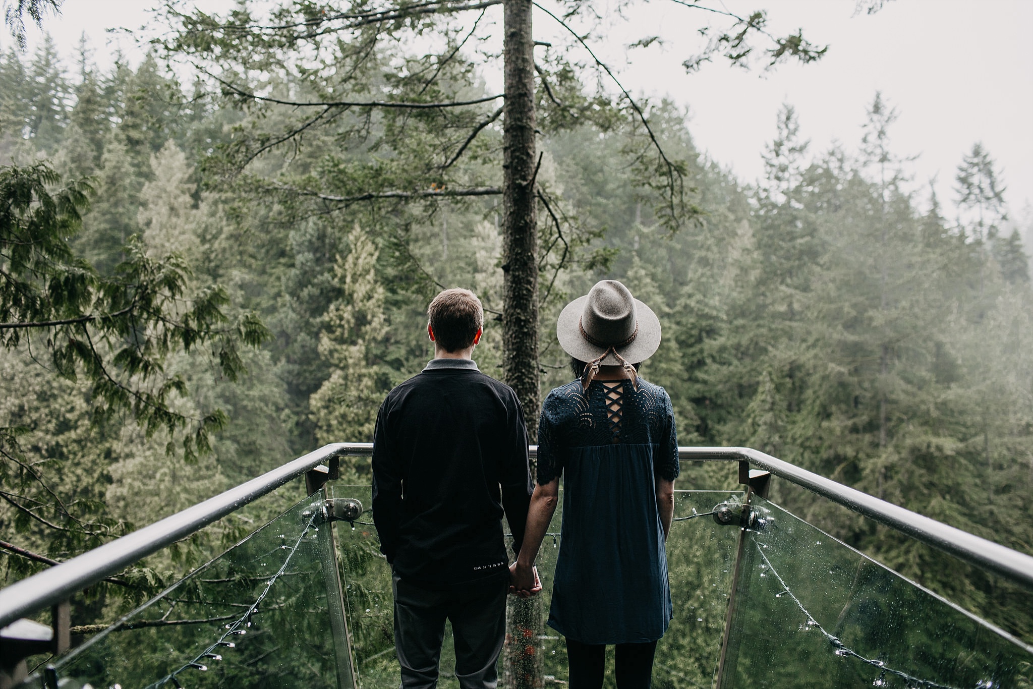 couple standing at lookout point capilano suspension bridge foggy rainy day