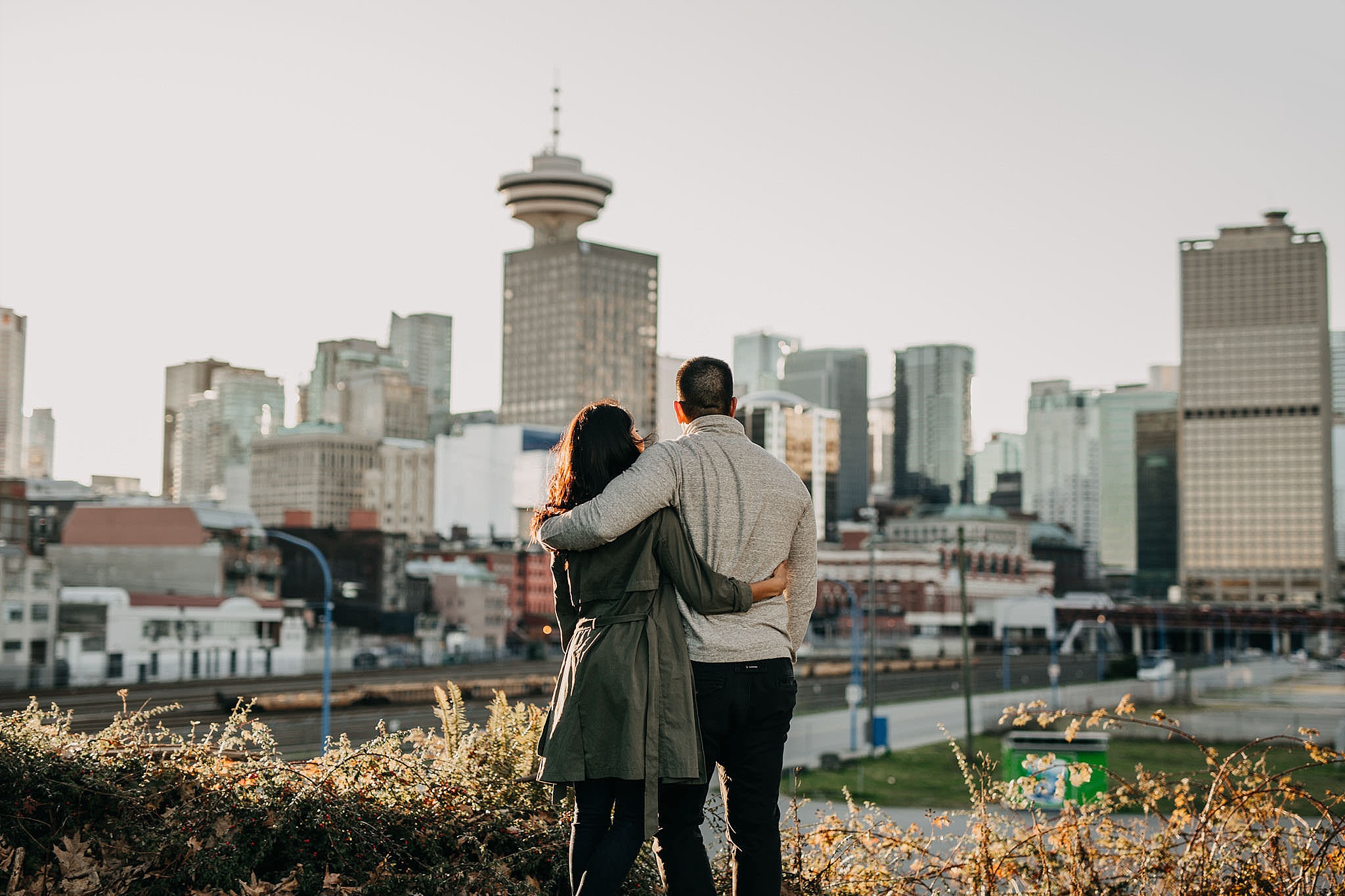 couple in front of vancouver skyline city buildings urban