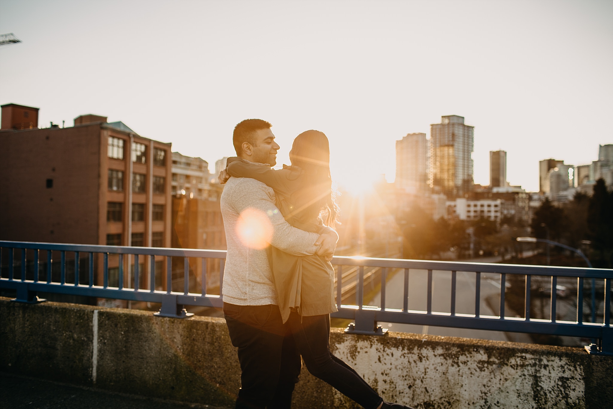 couple spinning in air sunset downtown vancouver engagement session