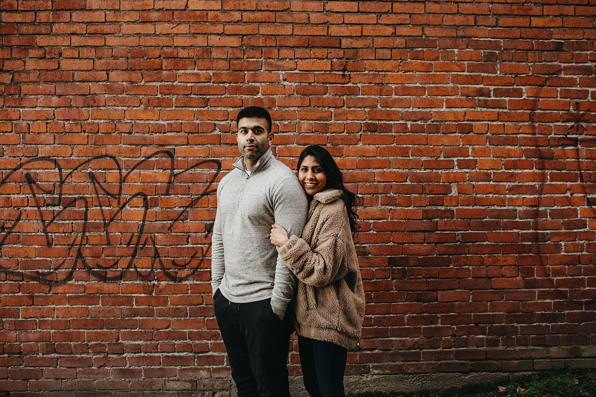 couple in front of brick wall downtown vancouver urban engagement
