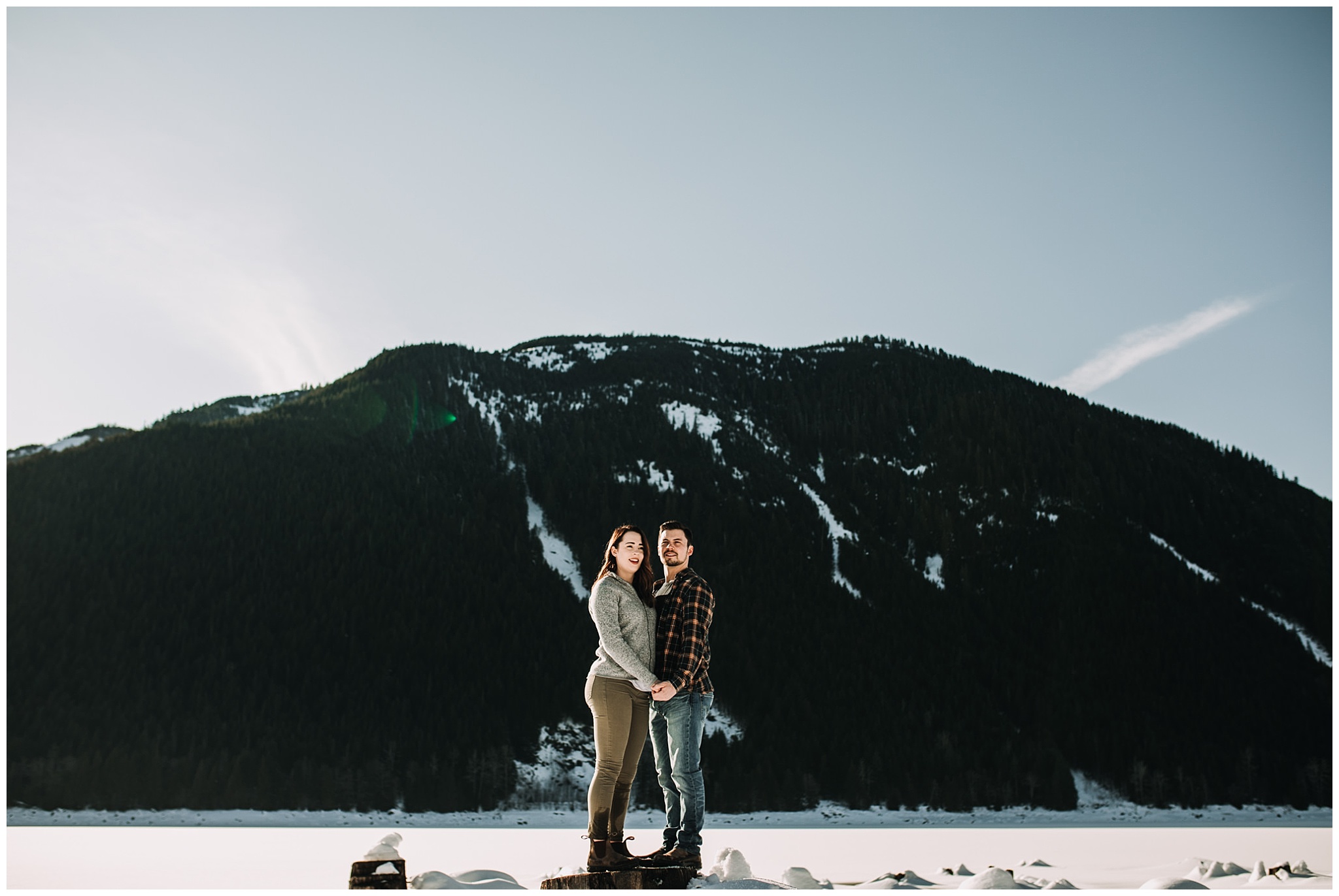 couple standing on tree stump jones lake engagement session