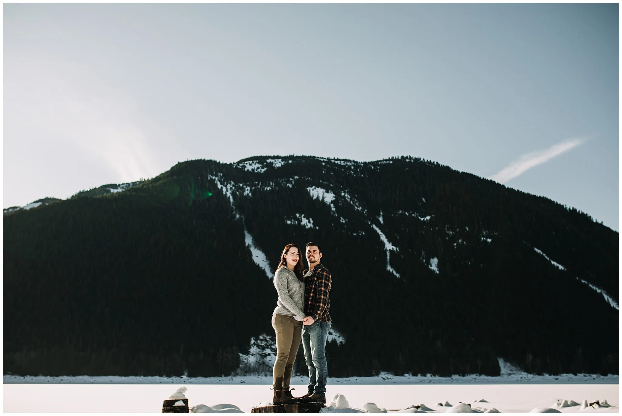 couple standing on tree stump jones lake engagement session