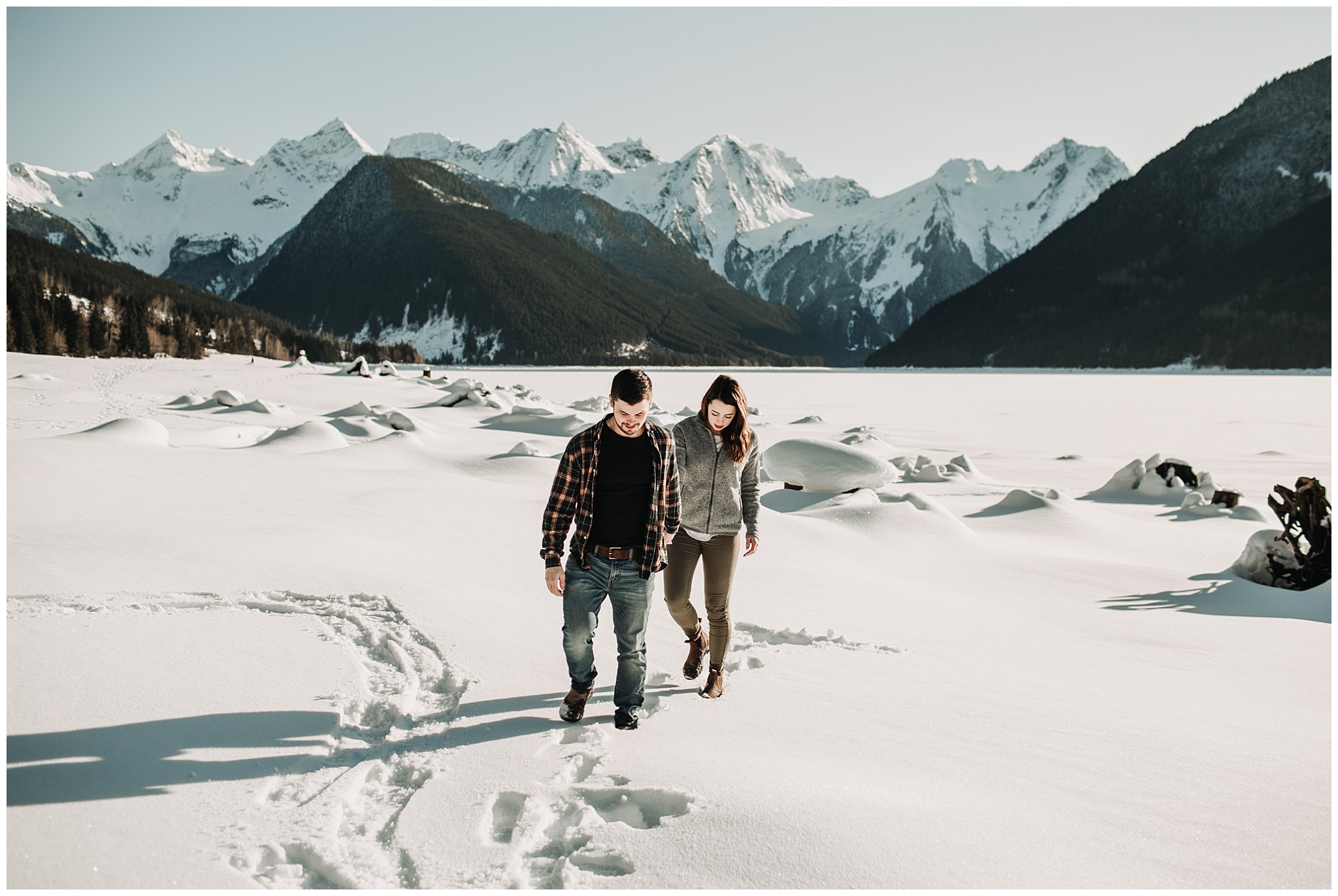 couple walking in snow at jones lake for engagement session
