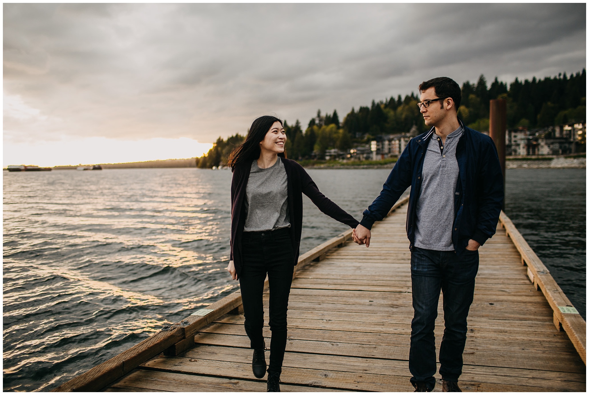 couple walking on dock holding hands sunset north vancouver engagement