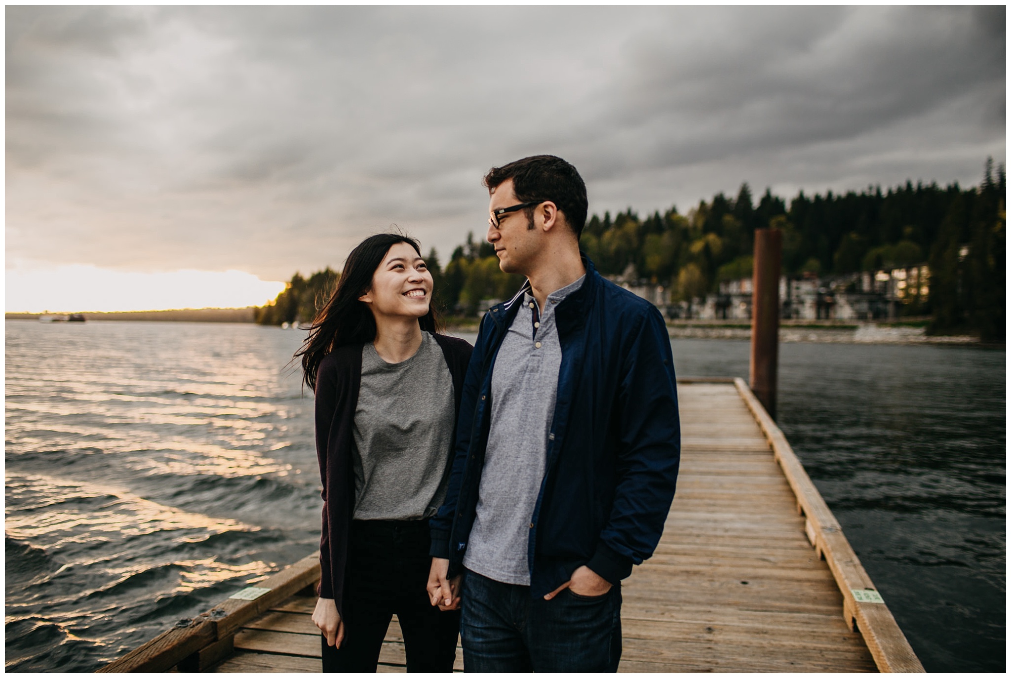 couple walking on dock sunset holding hands north vancouver engagement