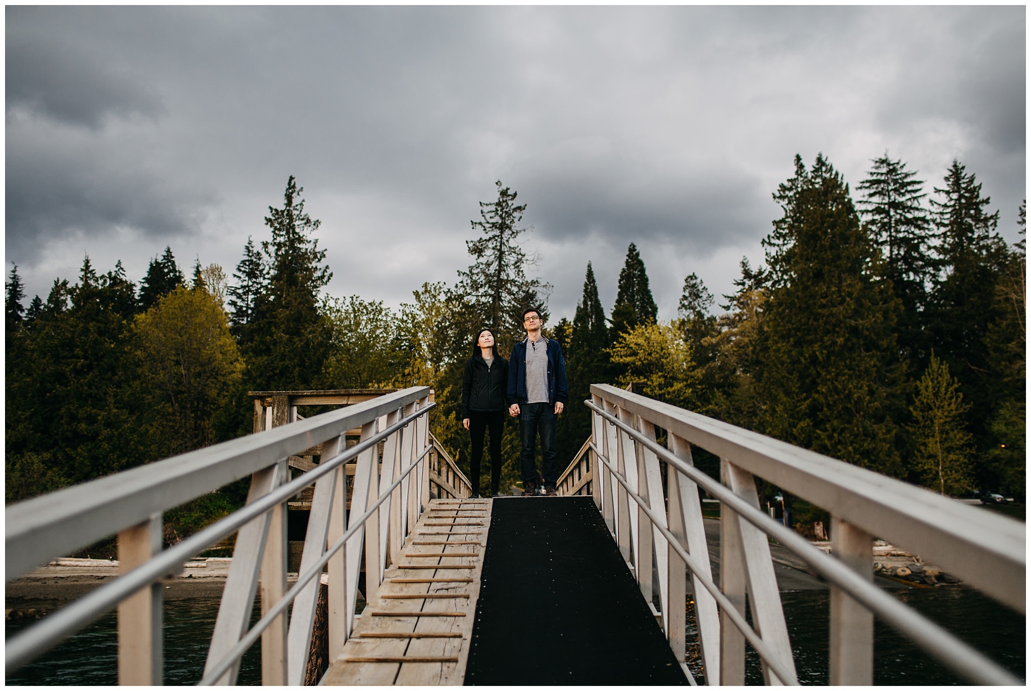couple dock trees forest moody sky sunset vancouver engagement