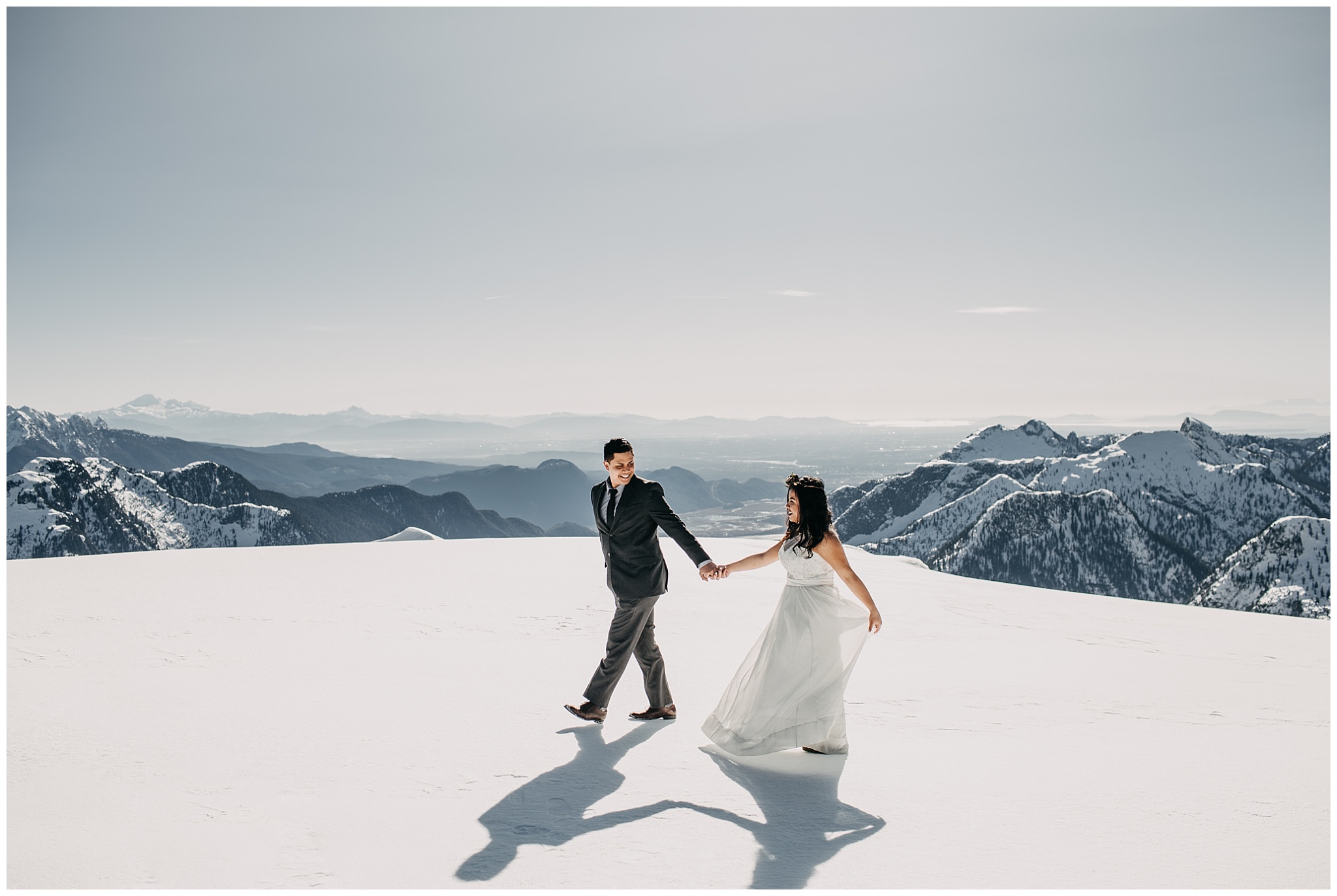 bride groom walking on snowy mountaintop sky helicopters wedding portraits