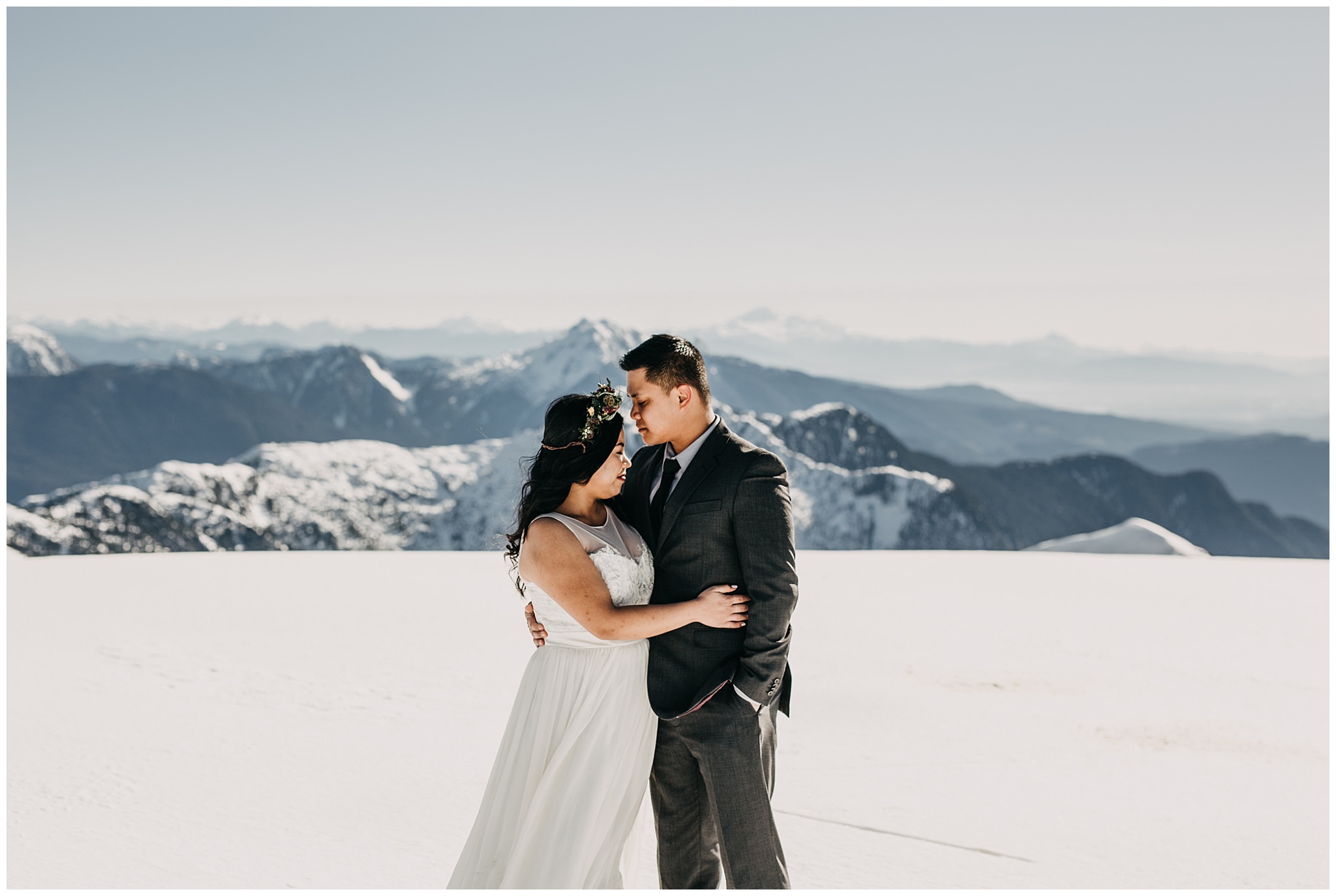 bride groom portrait on snowy mountaintop wedding day sky helicopters