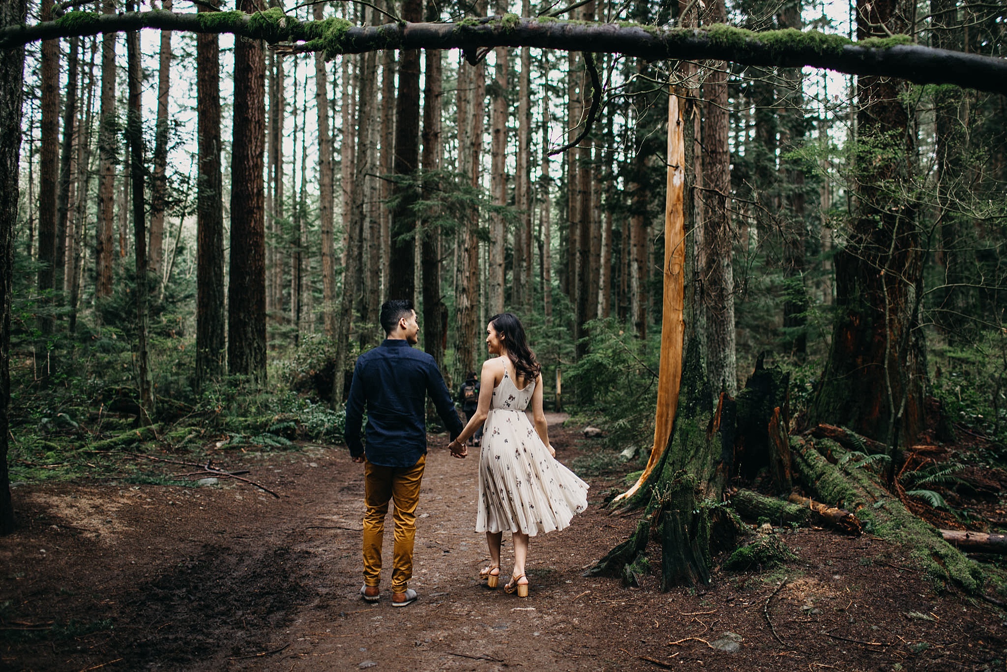couple walking through forest pacific spirit park engagement session vancouver