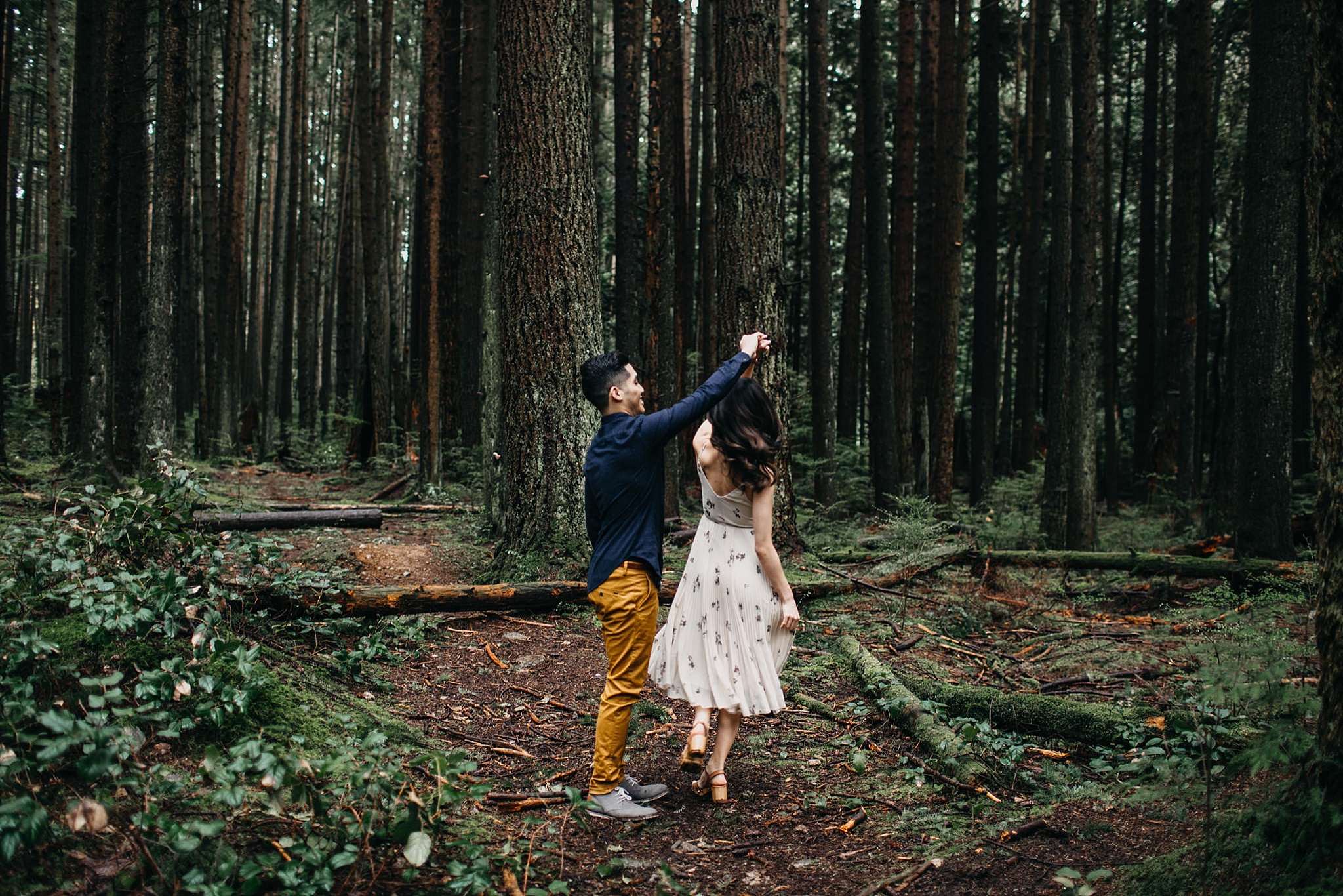 pacific spirit park engagement couple dancing in forest