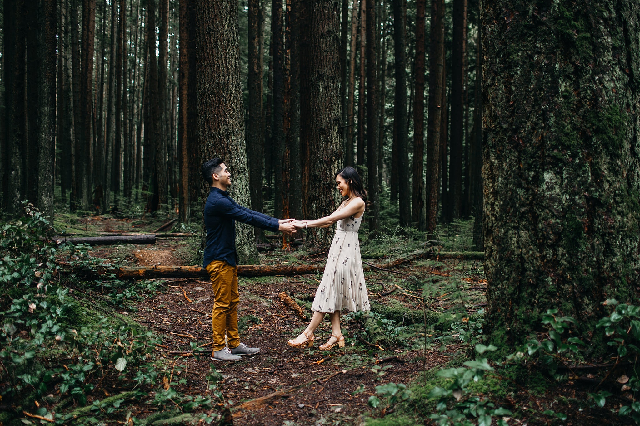 couple dancing in lush forest engagement session vancouver pacific spirit park
