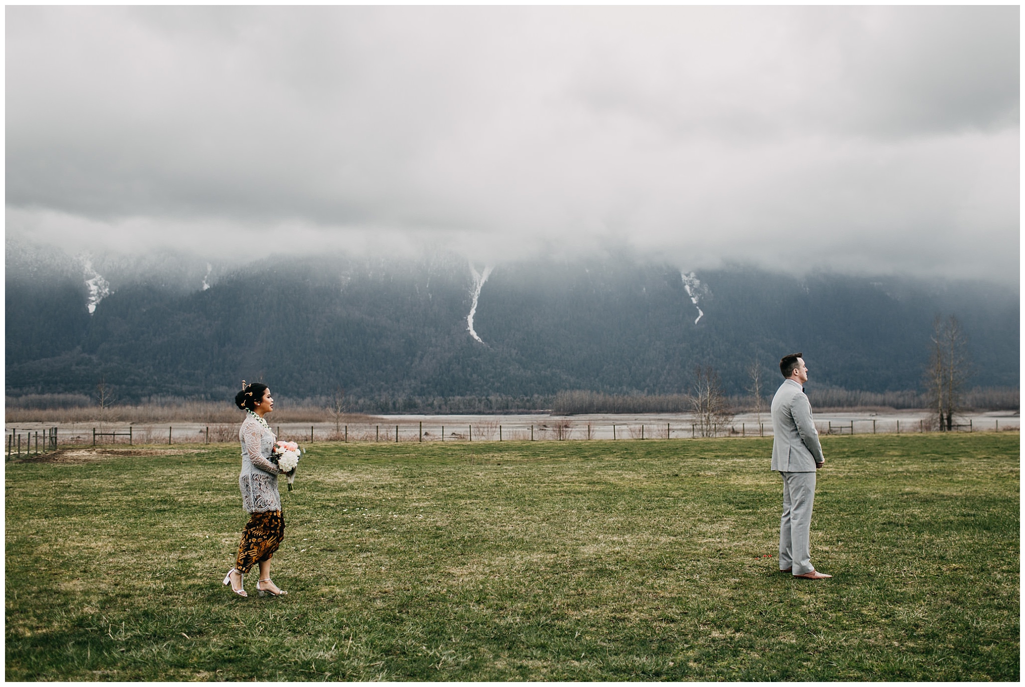 bride and groom first look at fraser river lodge wedding with mountain backdrop