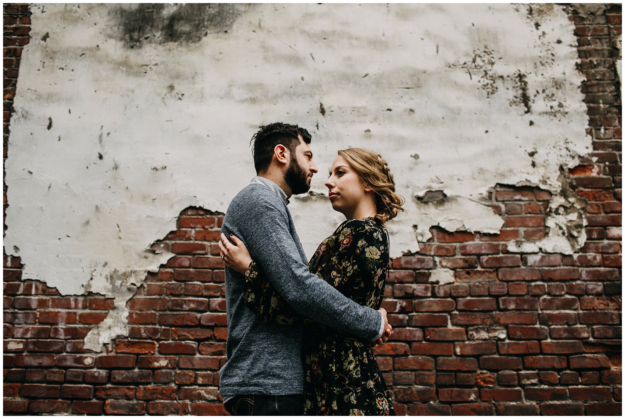 couple in front of brick wall downtown new west urban engagement session