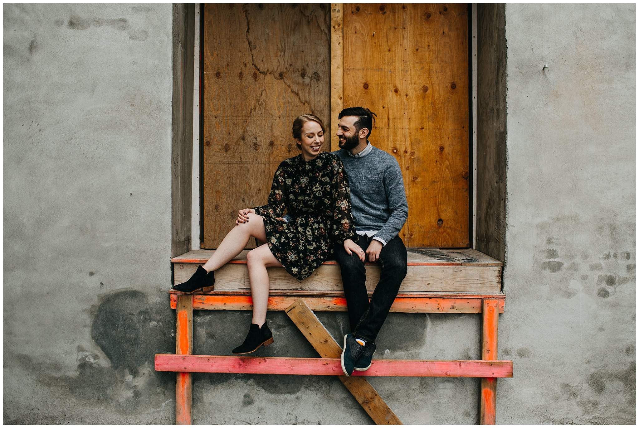 couple sitting in urban setting at downtown new west engagement session