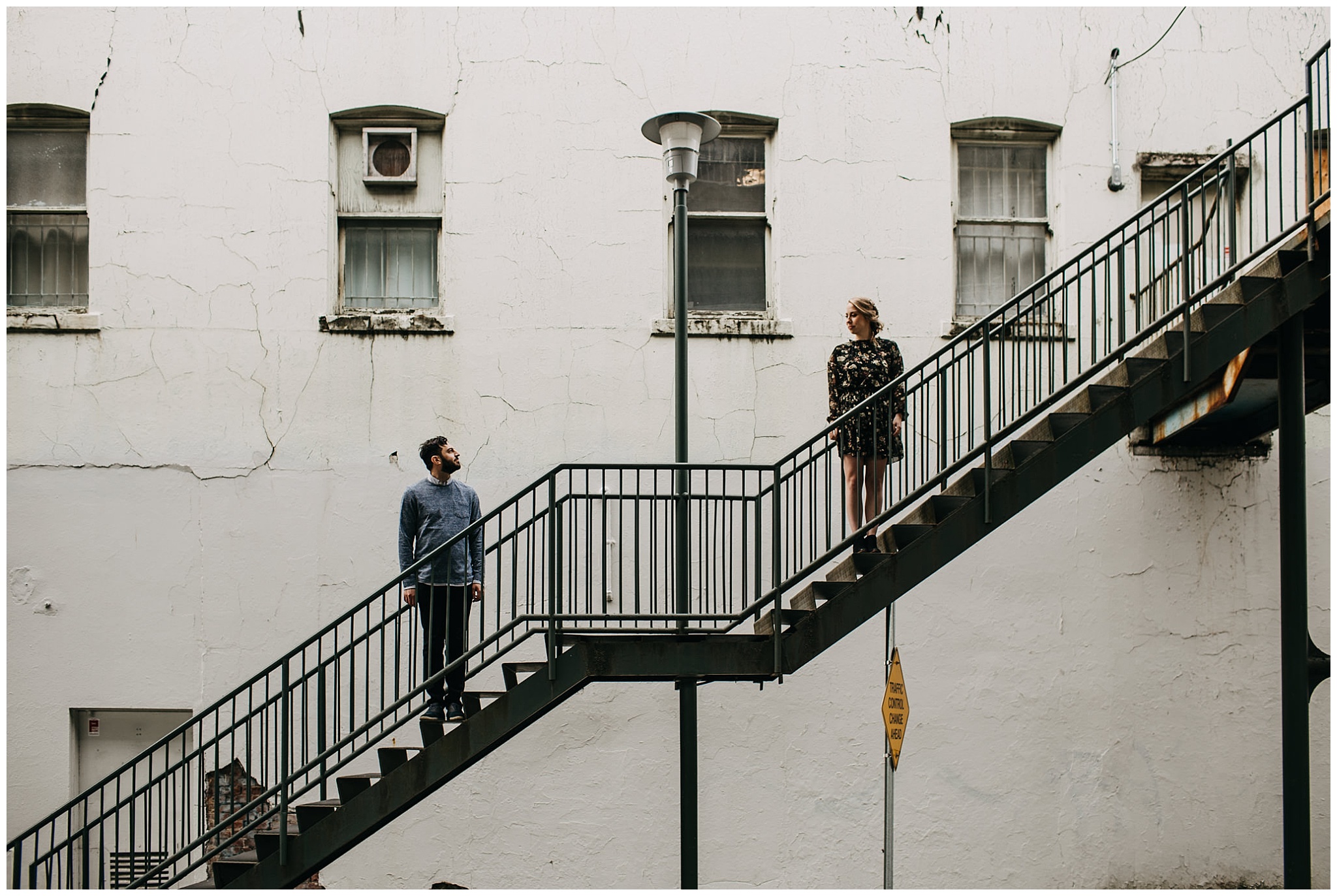 couple standing on stairs at downtown new west engagement session