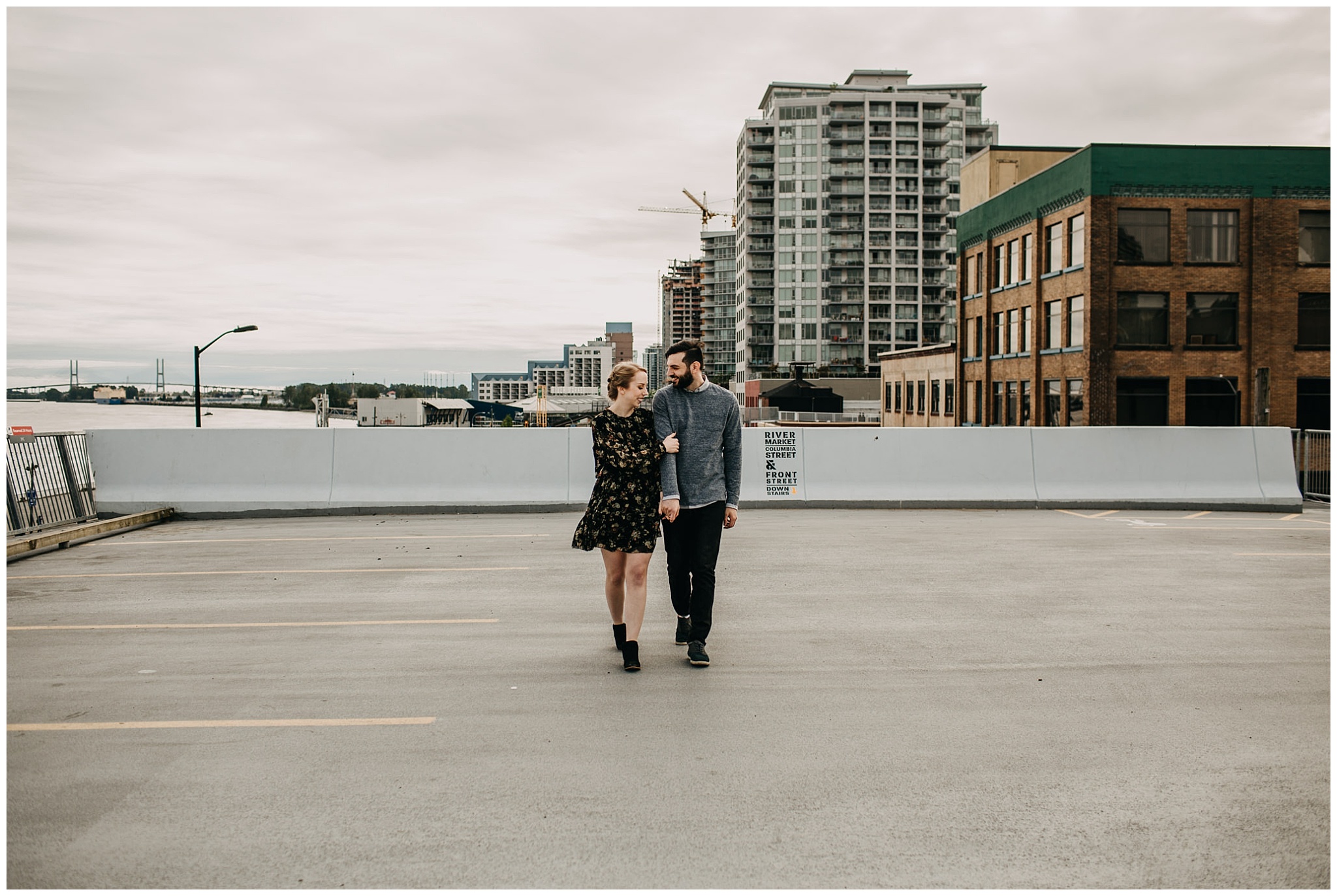 couple walking on rooftop parkade at downtown new west engagement session