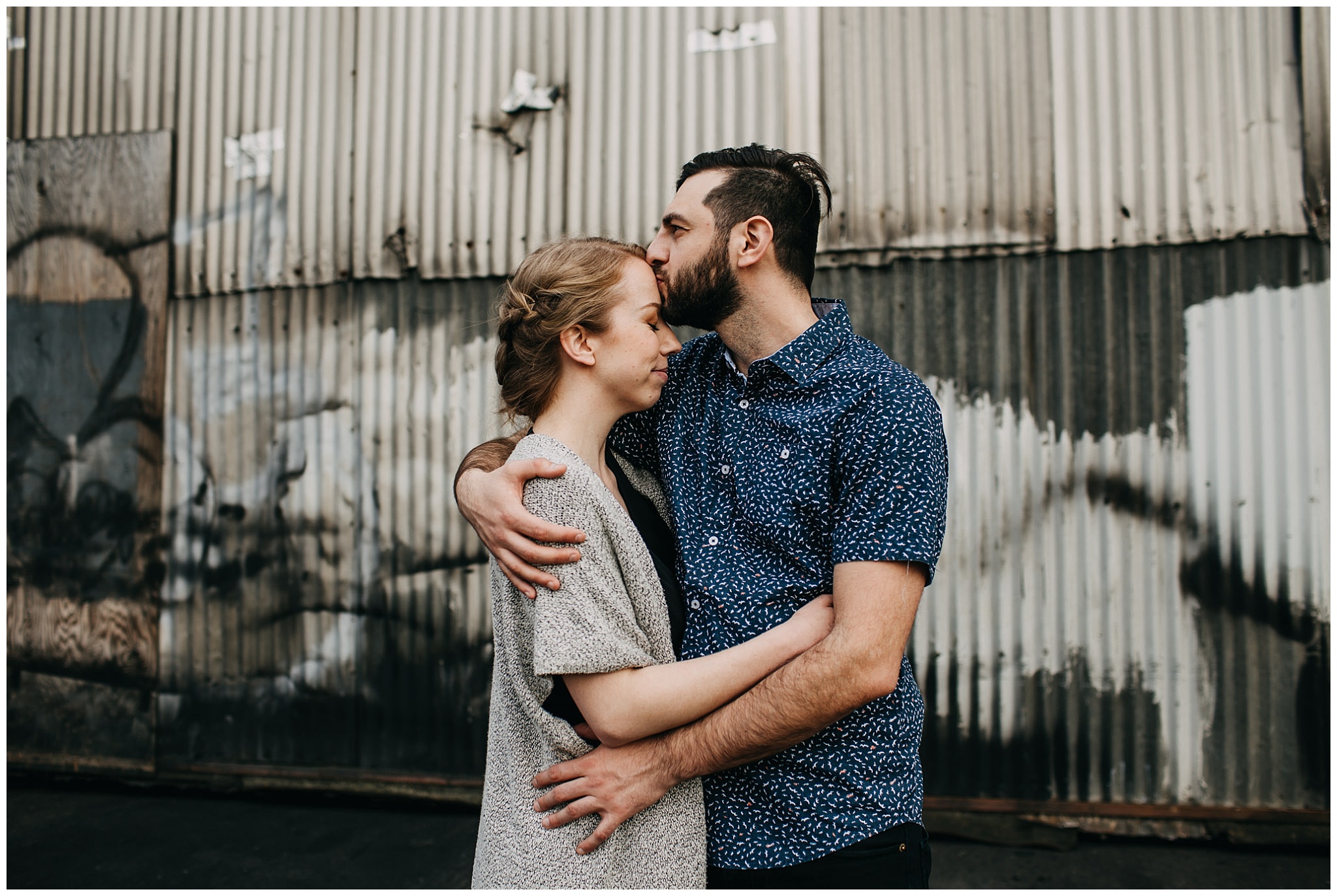 couple hugging in industrial urban setting at downtown new west engagement session