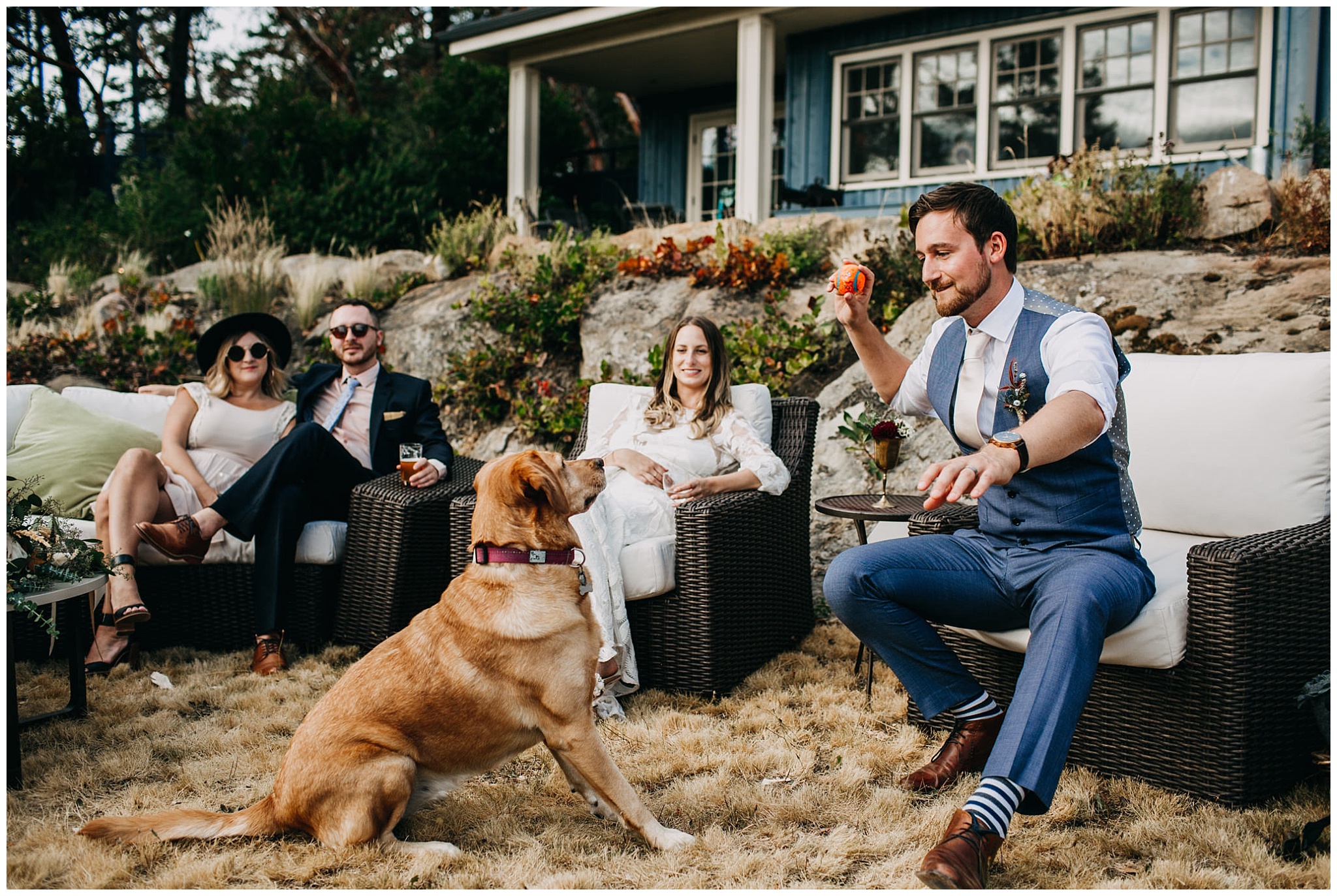 candid moment of groom playing fetch with dog at mayne island wedding