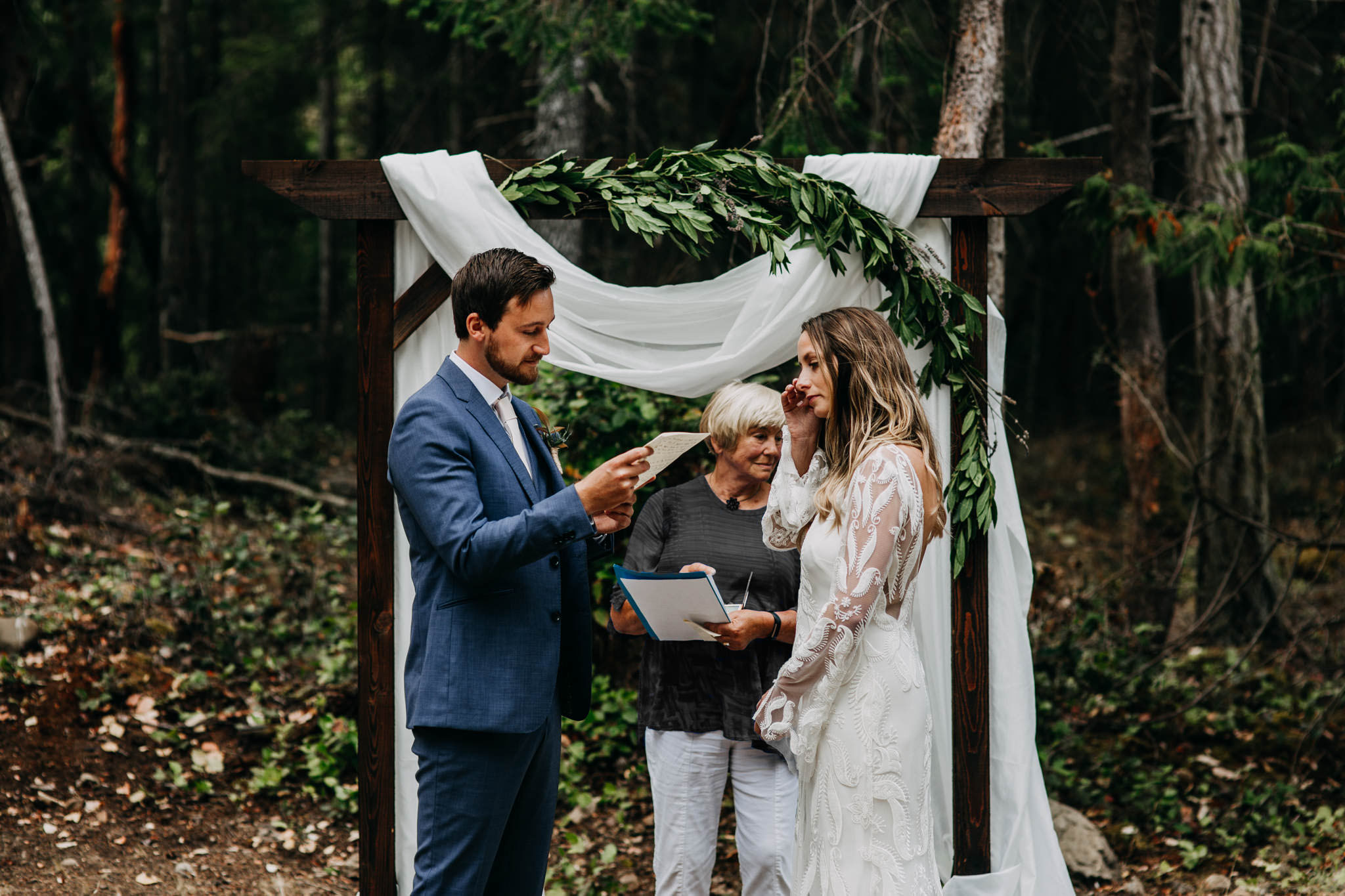 bride and groom exchanging vows at intimate mayne island backyard wedding