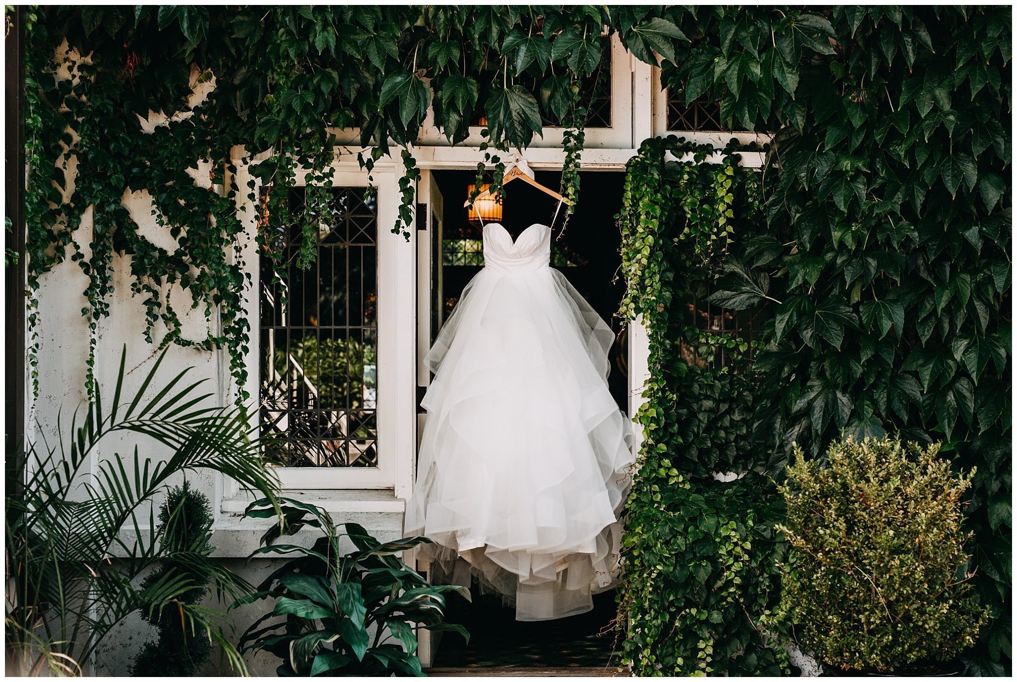 bride's dress hanging in ivy at hycroft manor wedding