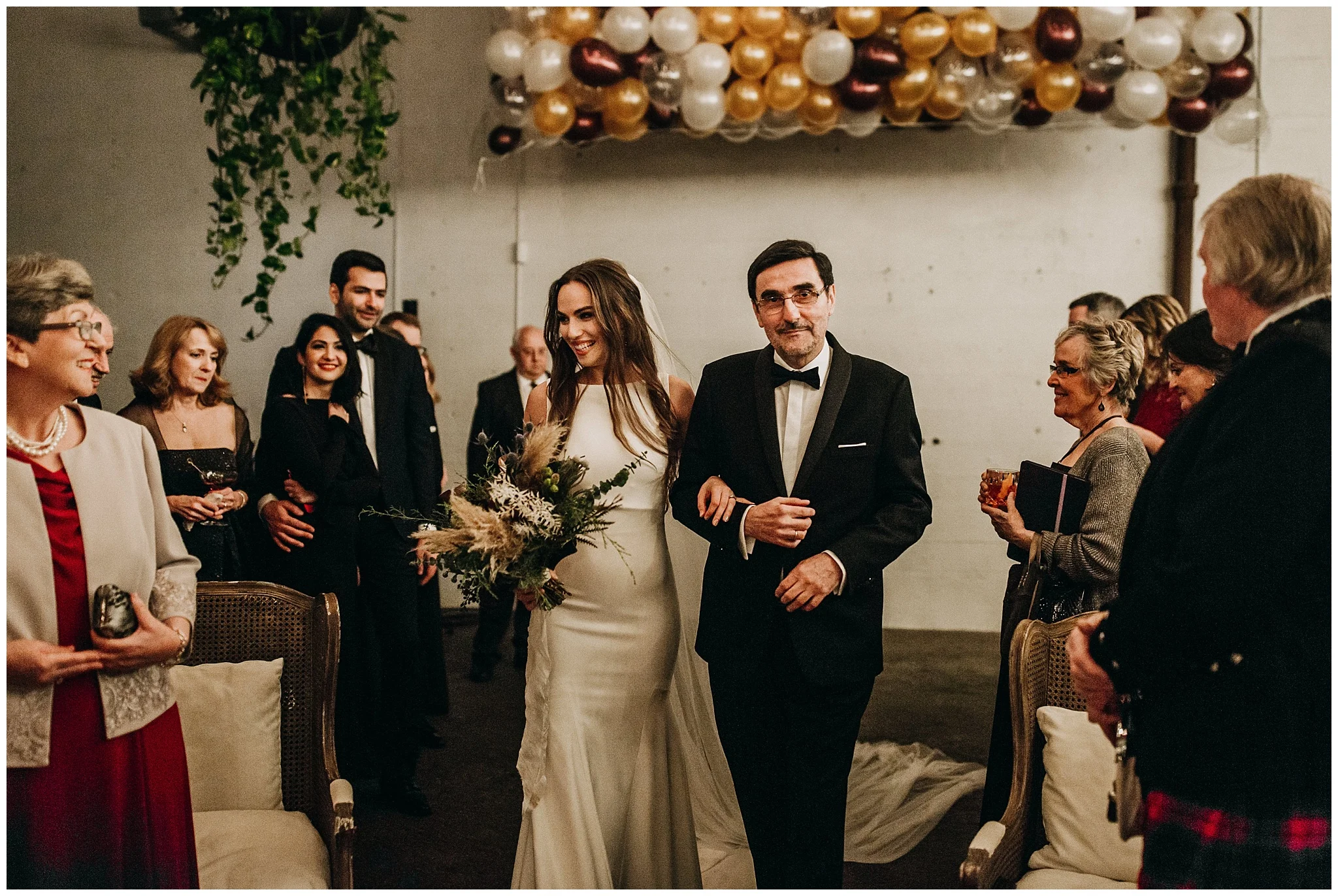 bride walking down aisle with father at settlement building wedding ceremony