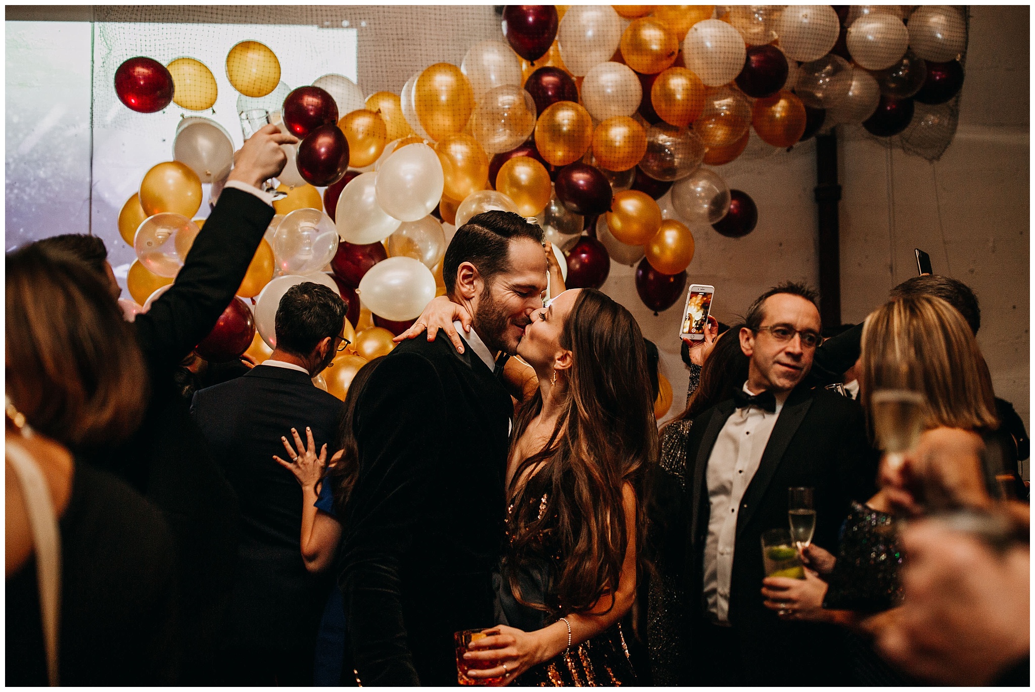 bride and groom new year's kiss with balloon drop at settlement building wedding