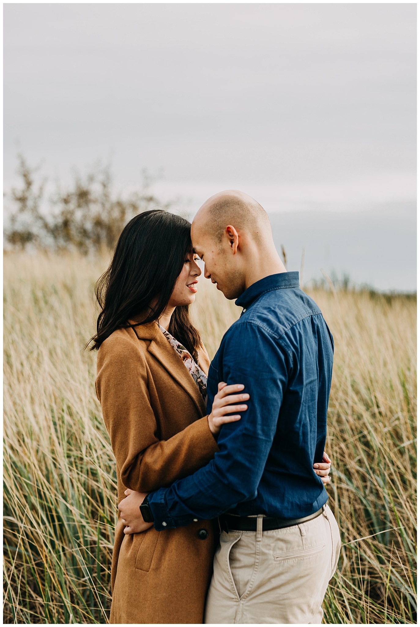 couple standing in tall grass at iona beach engagement