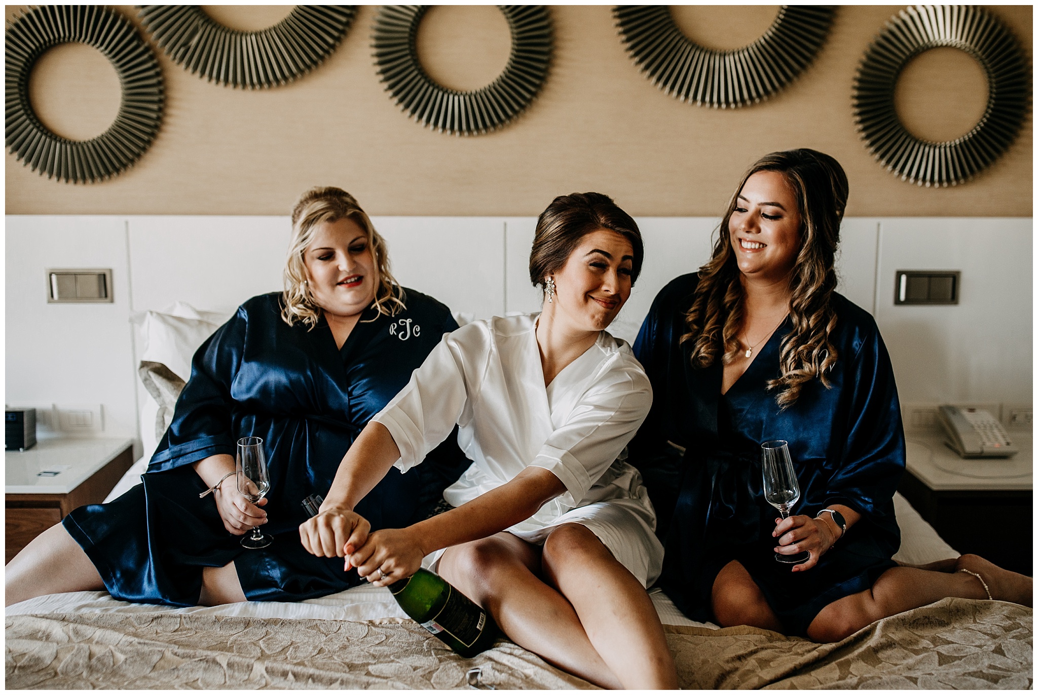 bride and bridesmaids popping champagne at cancun mexico wedding