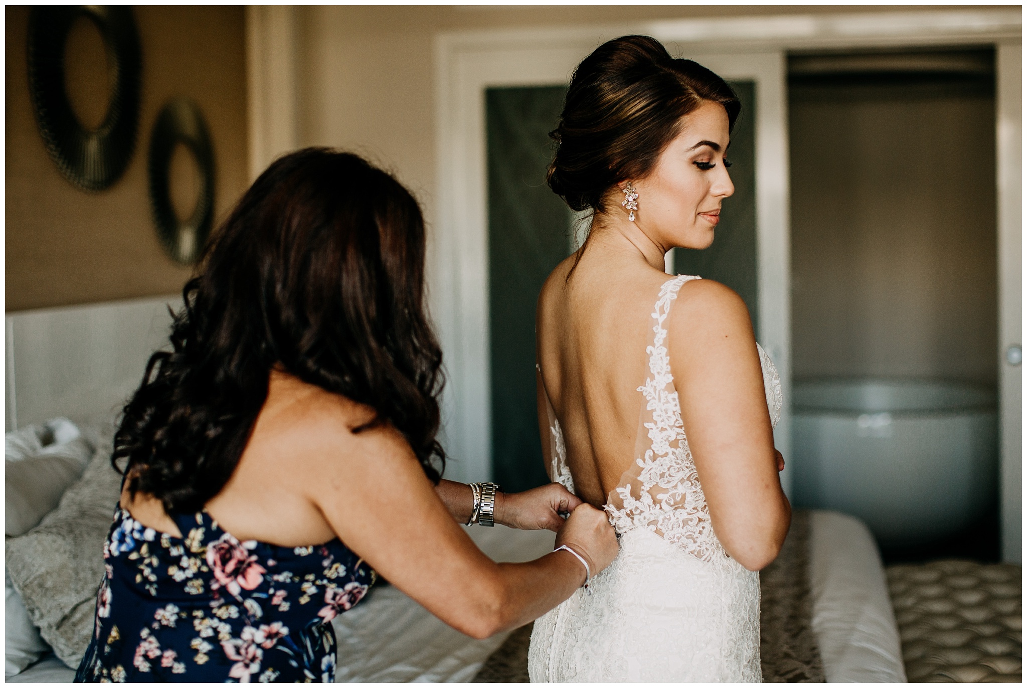 mother of bride doing up bride's dress at cancun mexico wedding